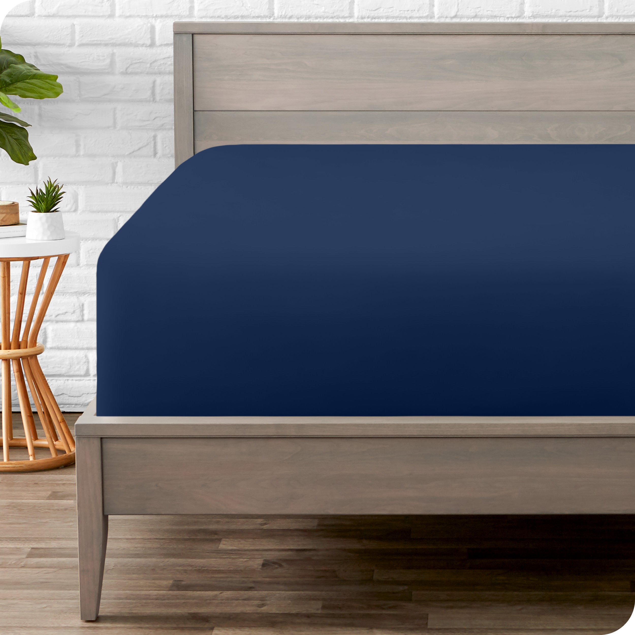 A modern bed with a fitted microfiber sheet on it