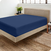 Corner view of a modern bed with a microfiber fitted sheet on the mattress. 