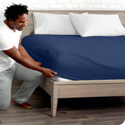 A man putting the microfiber fitted sheet on a mattress. 