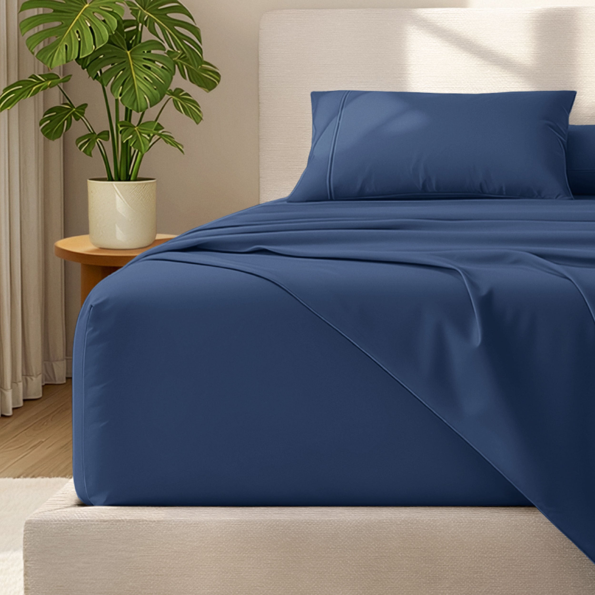 Microfiber bed sheets and pillowcases on a bed with a plant in the background