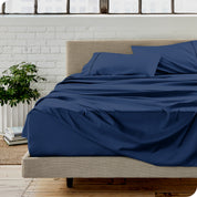 Microfiber sheets on a bed with a brick wall behind it