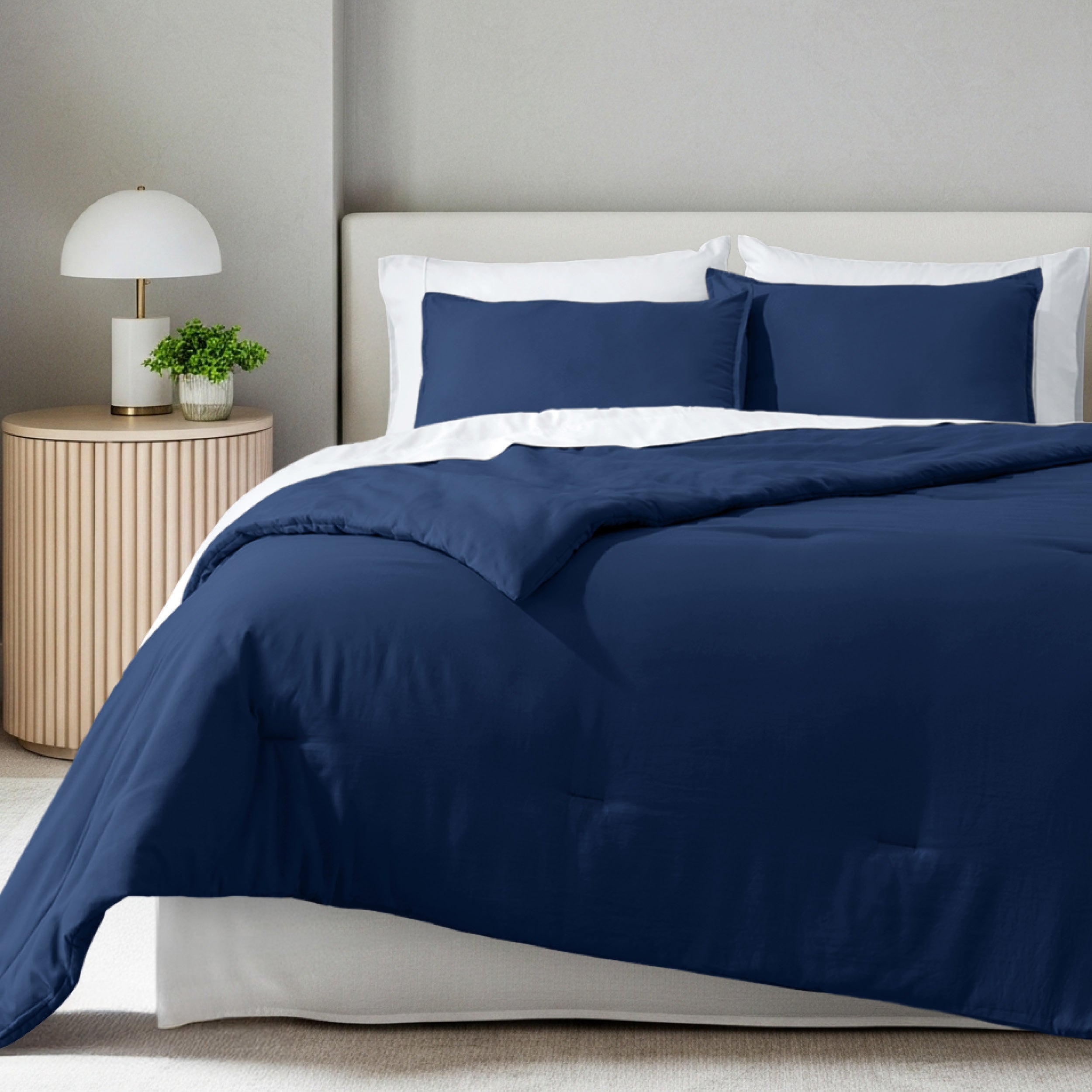 A comforter set on a bed in a bright modern room