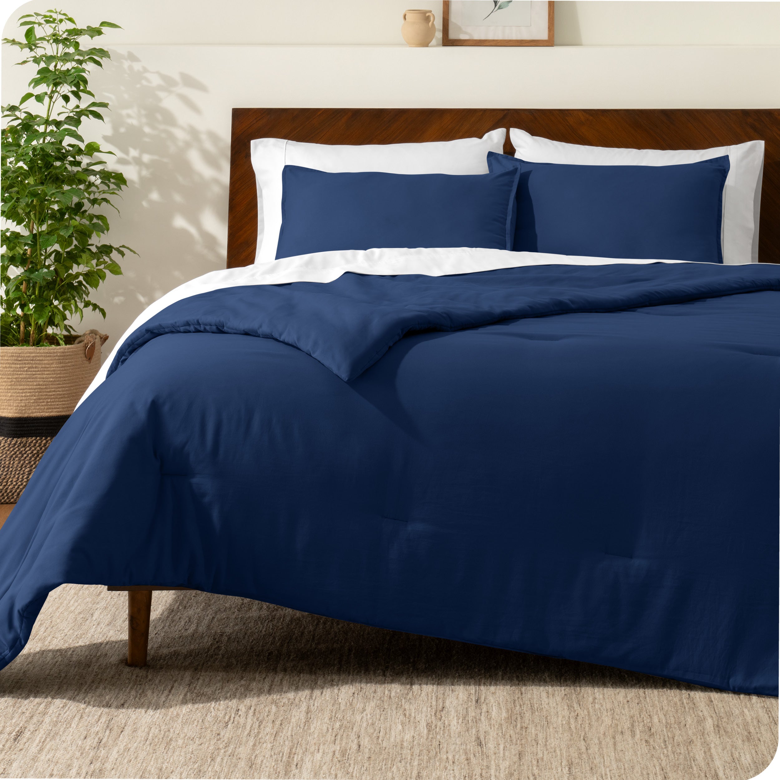 A comforter set on a bed with a dark wooden headboard