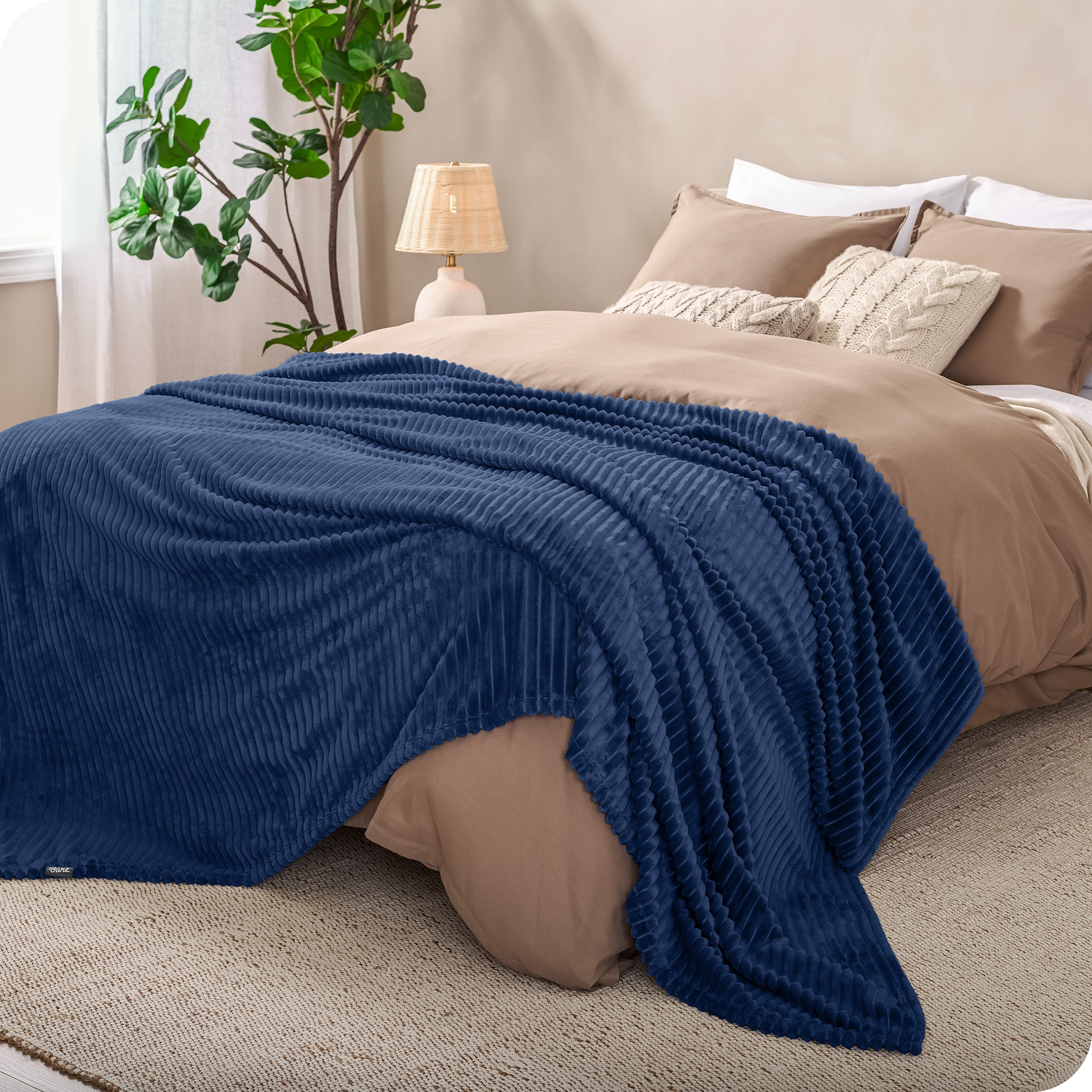 A microplush blanket spread out over the end of a bed