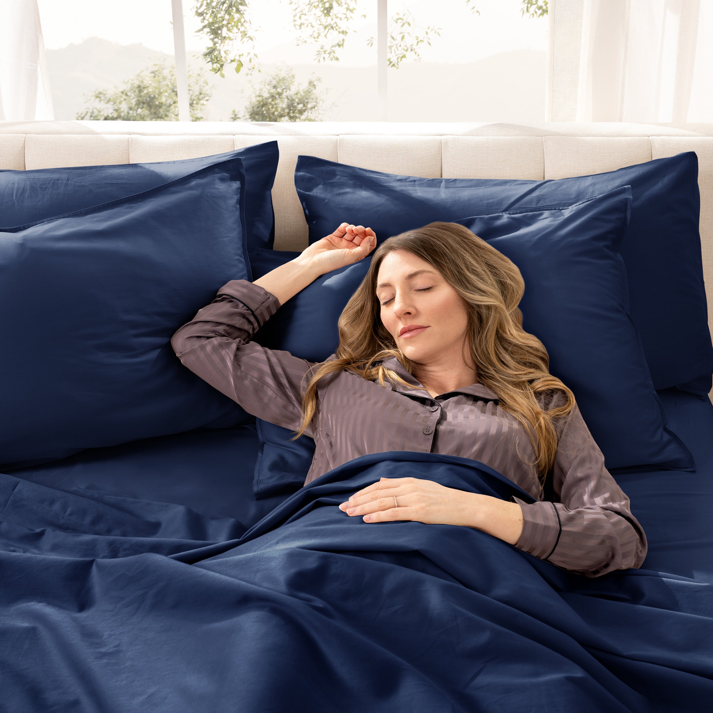 A woman sleeping on a bed made with organic cotton sateen sheets and pillowcases