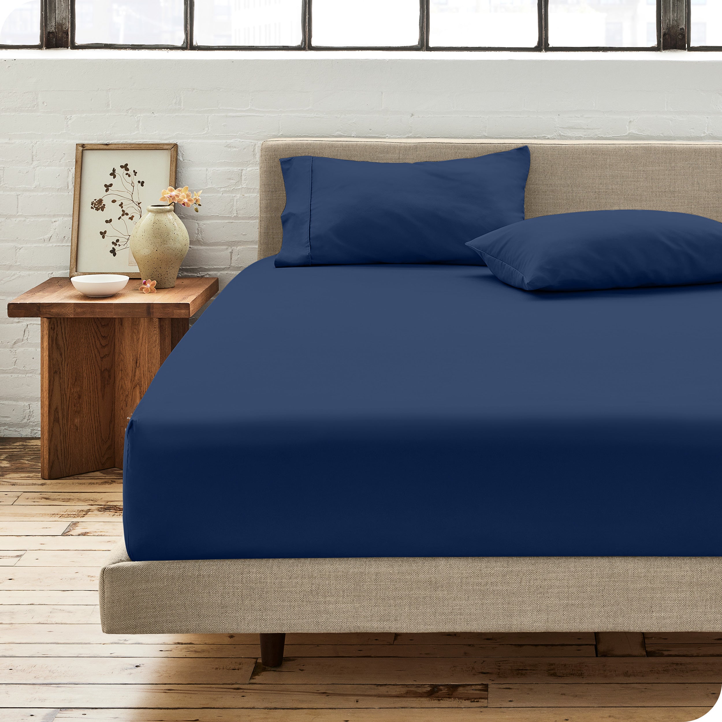Percale fitted sheet on a mattress with matching pillowcases on pillows