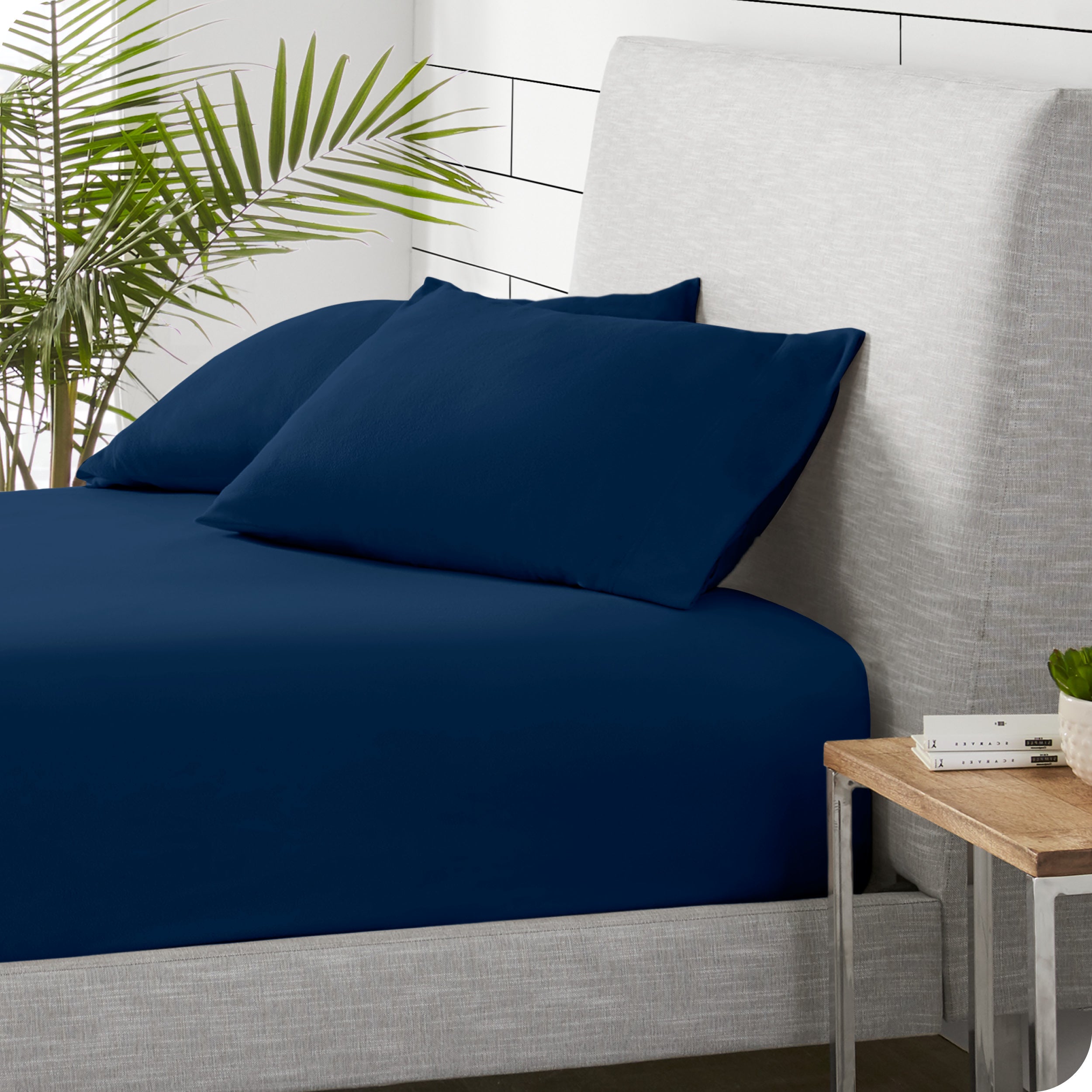 A sideview of a modern bed with a polar fleece fitted sheet on.