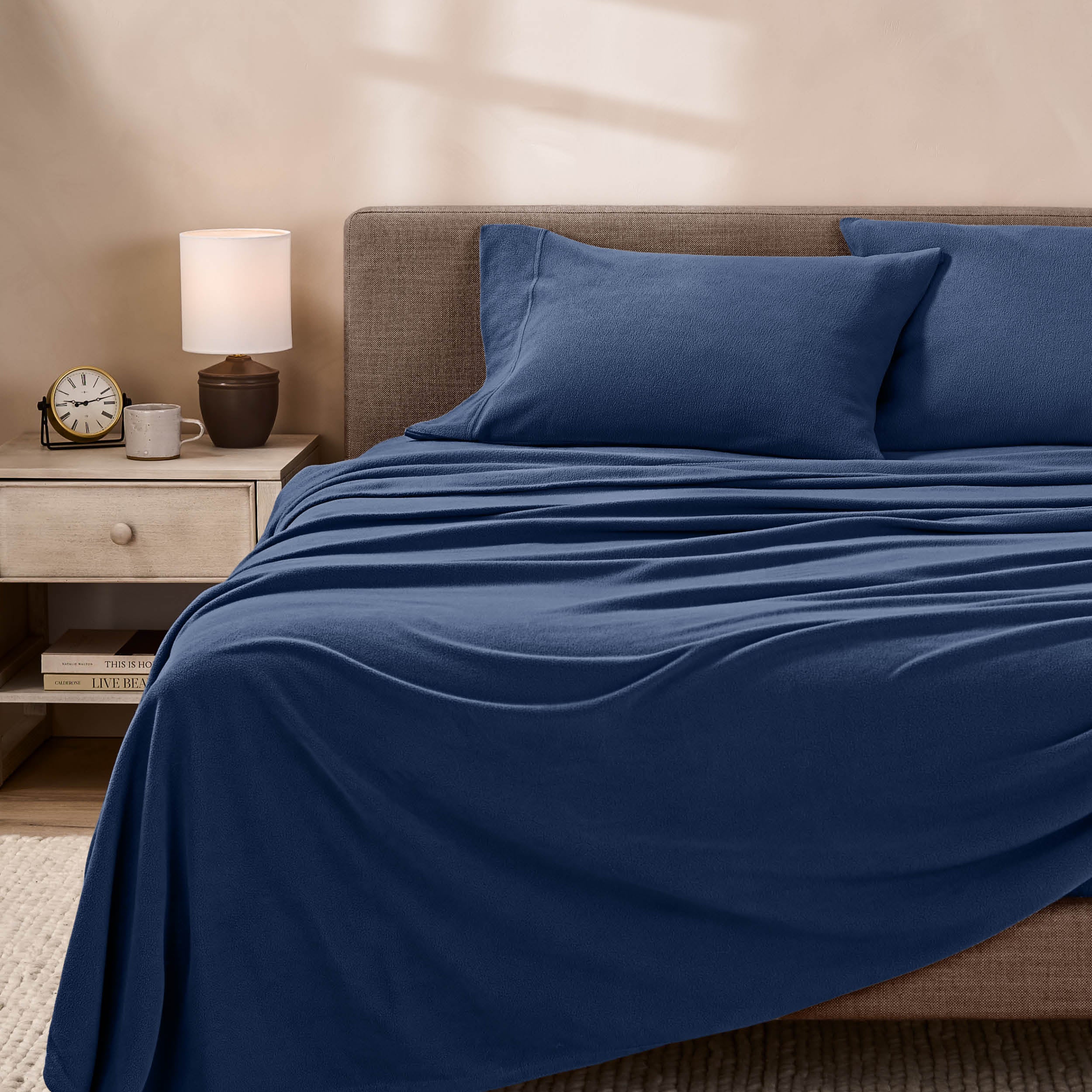 View of fleece sheets from the end of a bed with the top sheet draped over the side and end