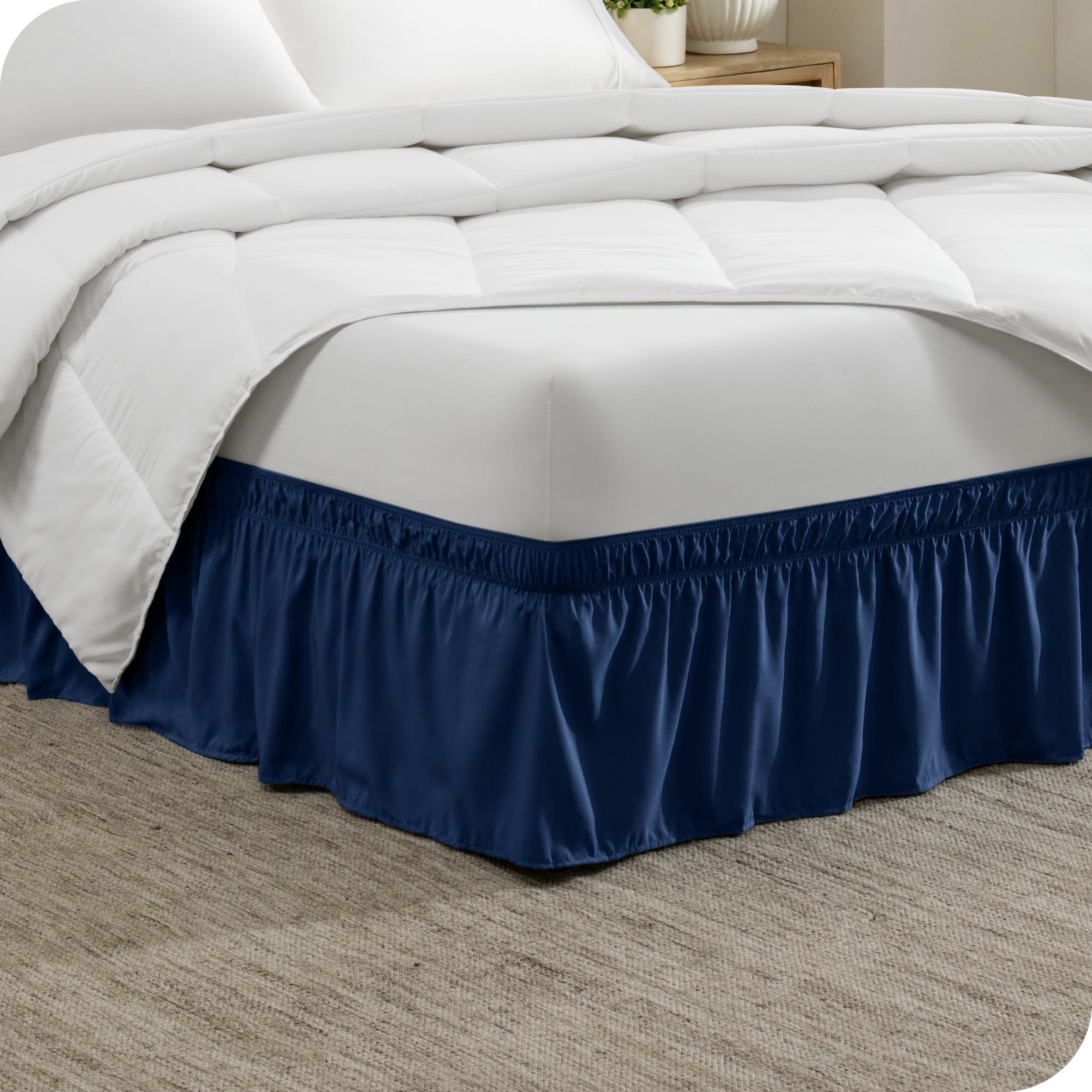 The corner of a bed with a polyester bed skirt on it