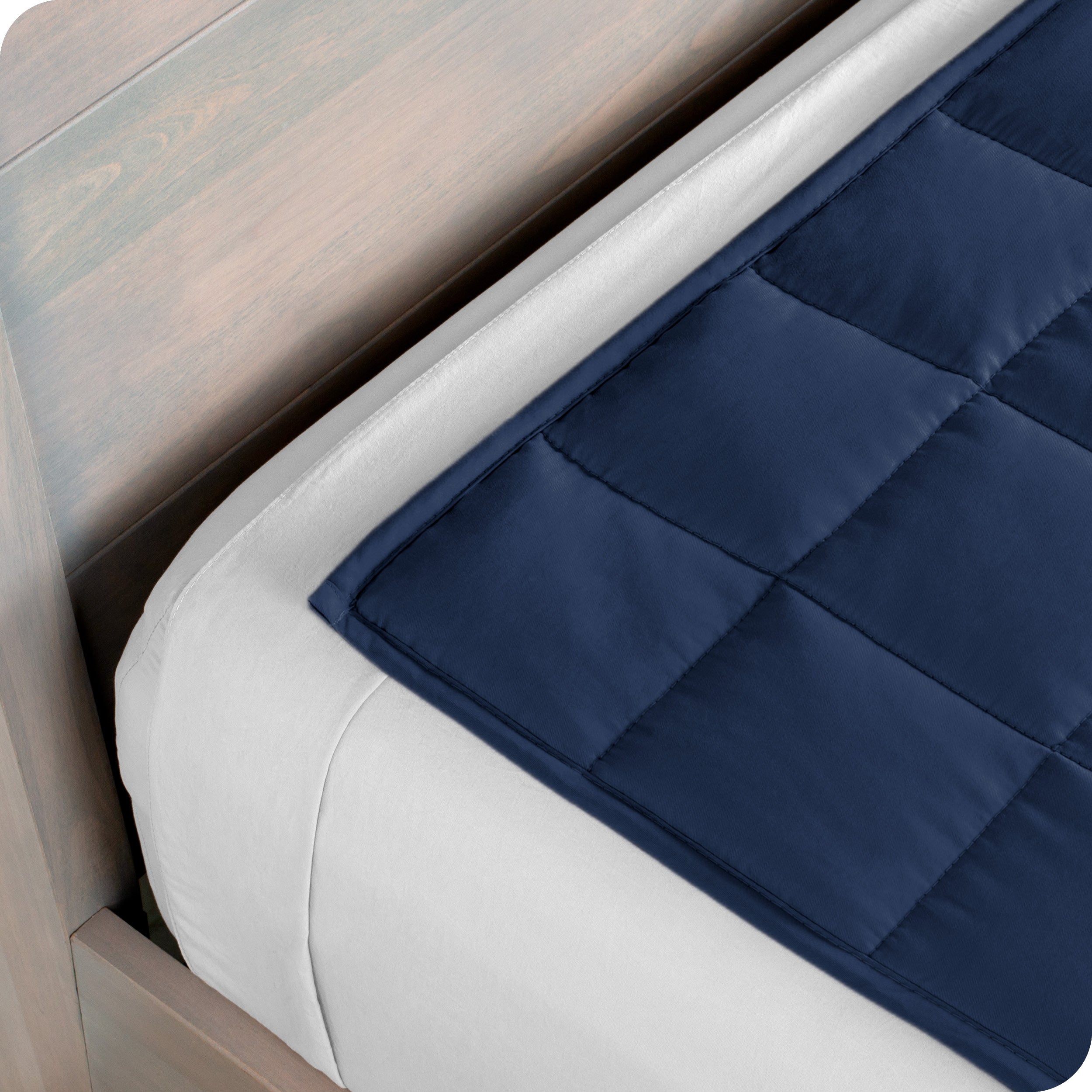 Close up of the corner of a weighted blanket on a bed