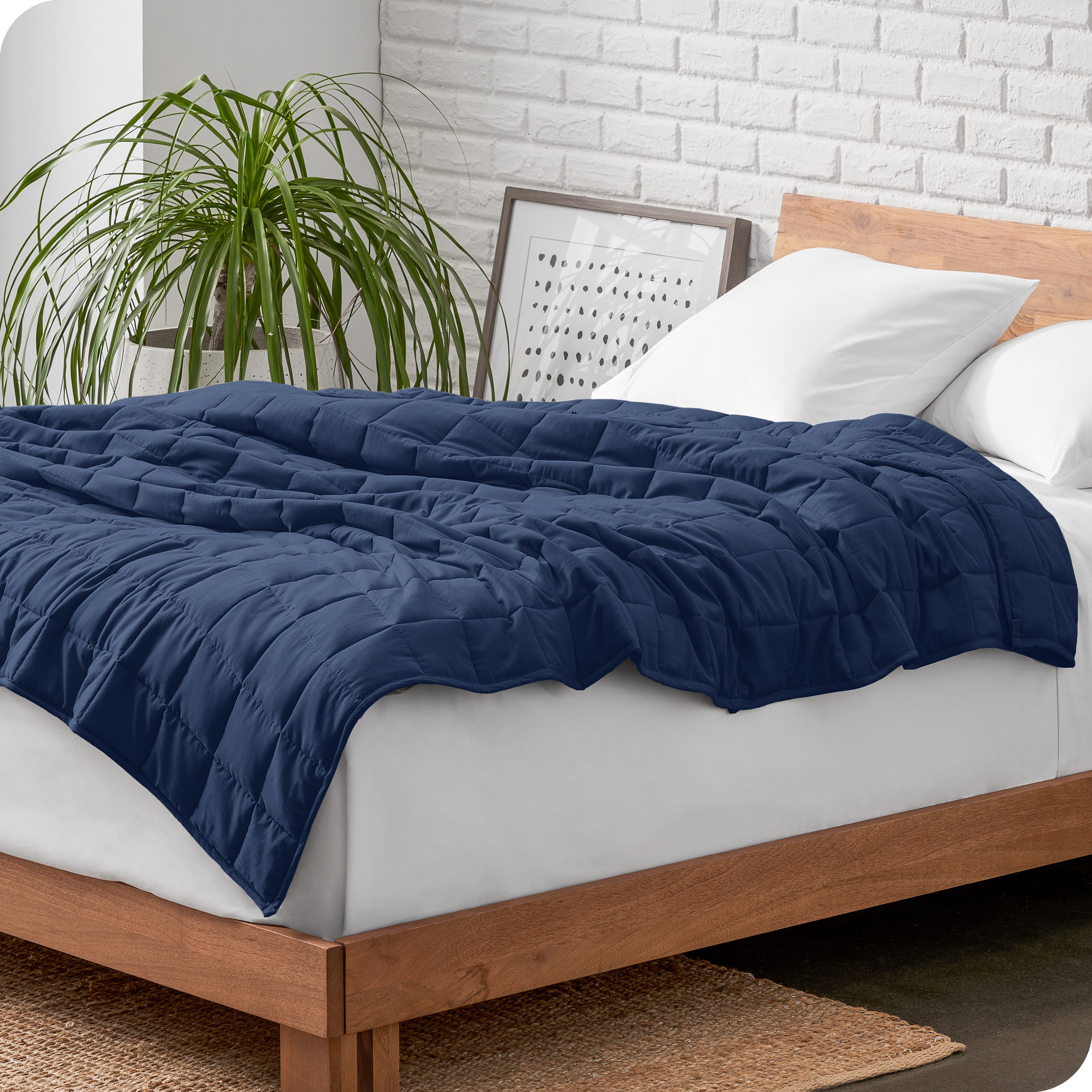 A cotton weighted blanket is loosely draped over a bed