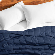 Close up of a weighted blanket on a bed with  2 pillows