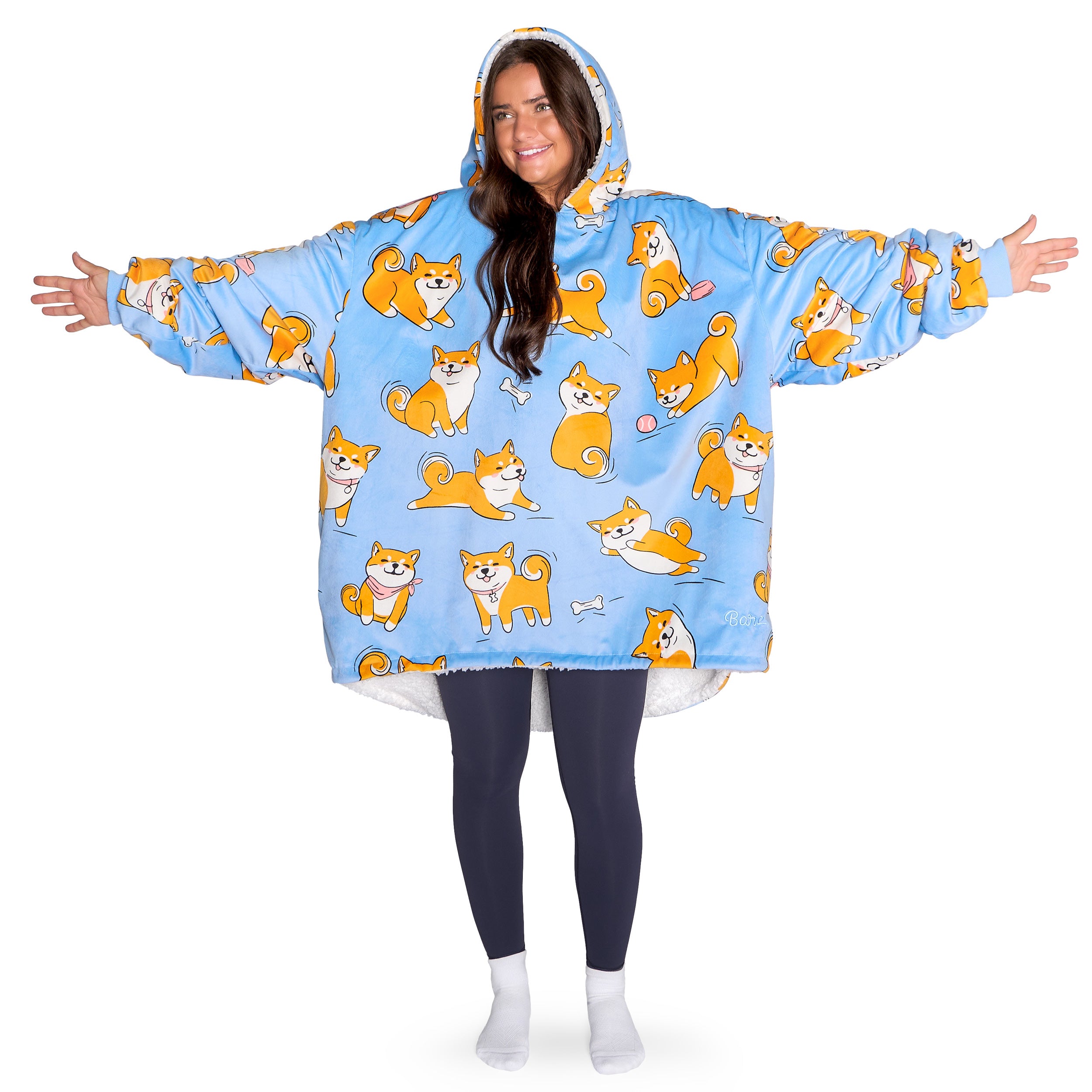 An adult with a hooded wearable blanket on