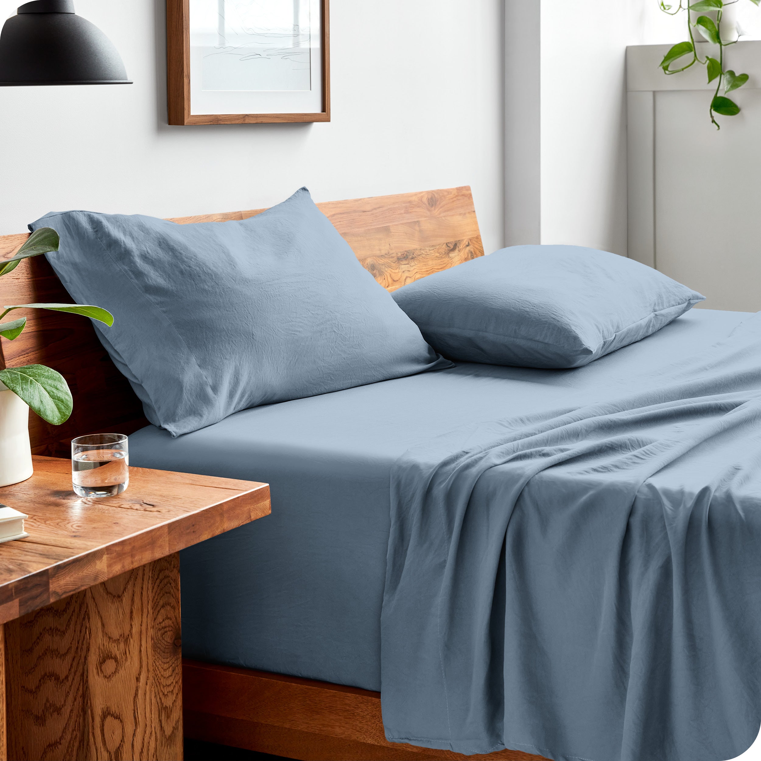 Side view of bed made with fitted sheet, pillowcases, and top sheet