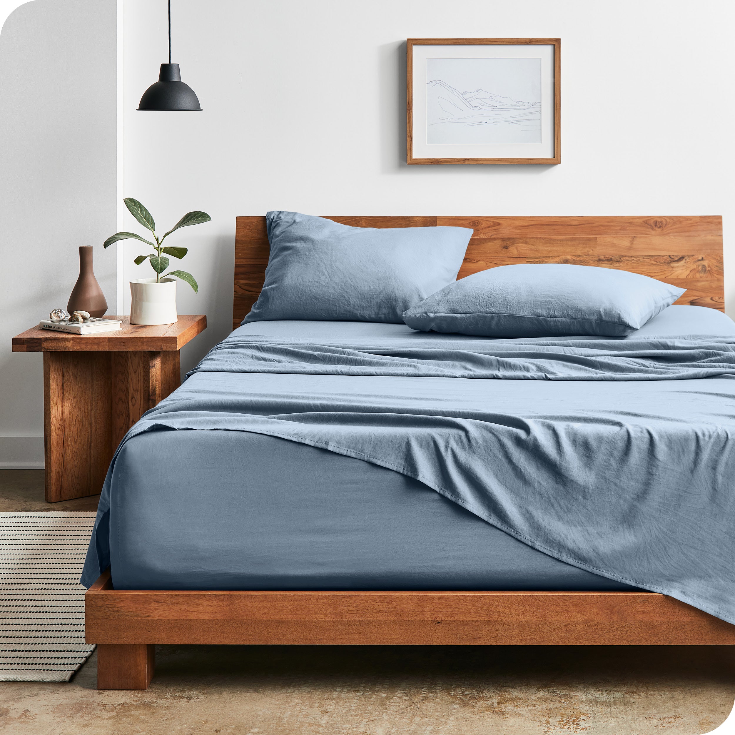 Modern bedroom with Sandwashed sheets draped over the end and side of mattress
