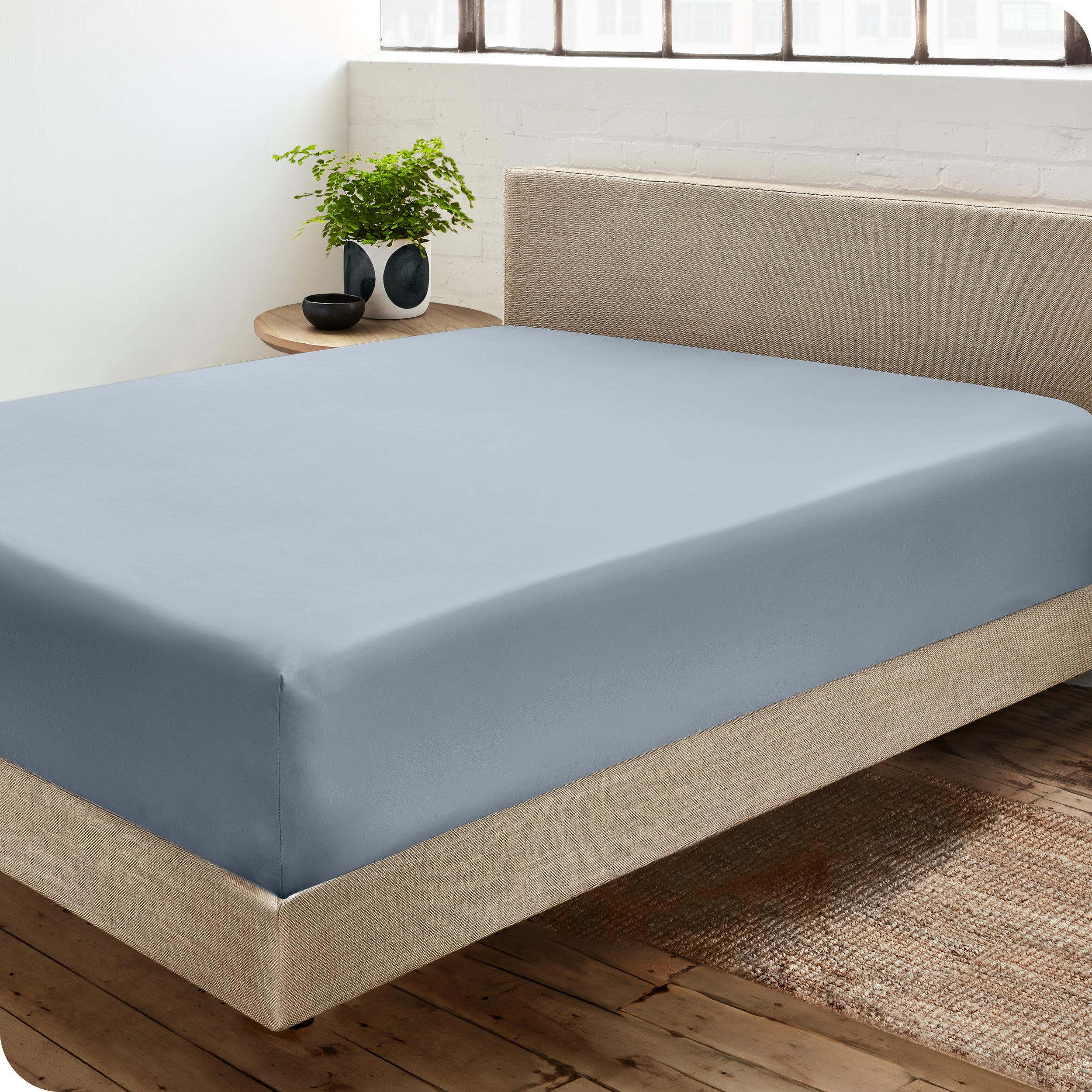 A sateen fitted sheet on a bed