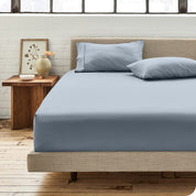 Percale fitted sheet on a mattress with matching pillowcases on pillows