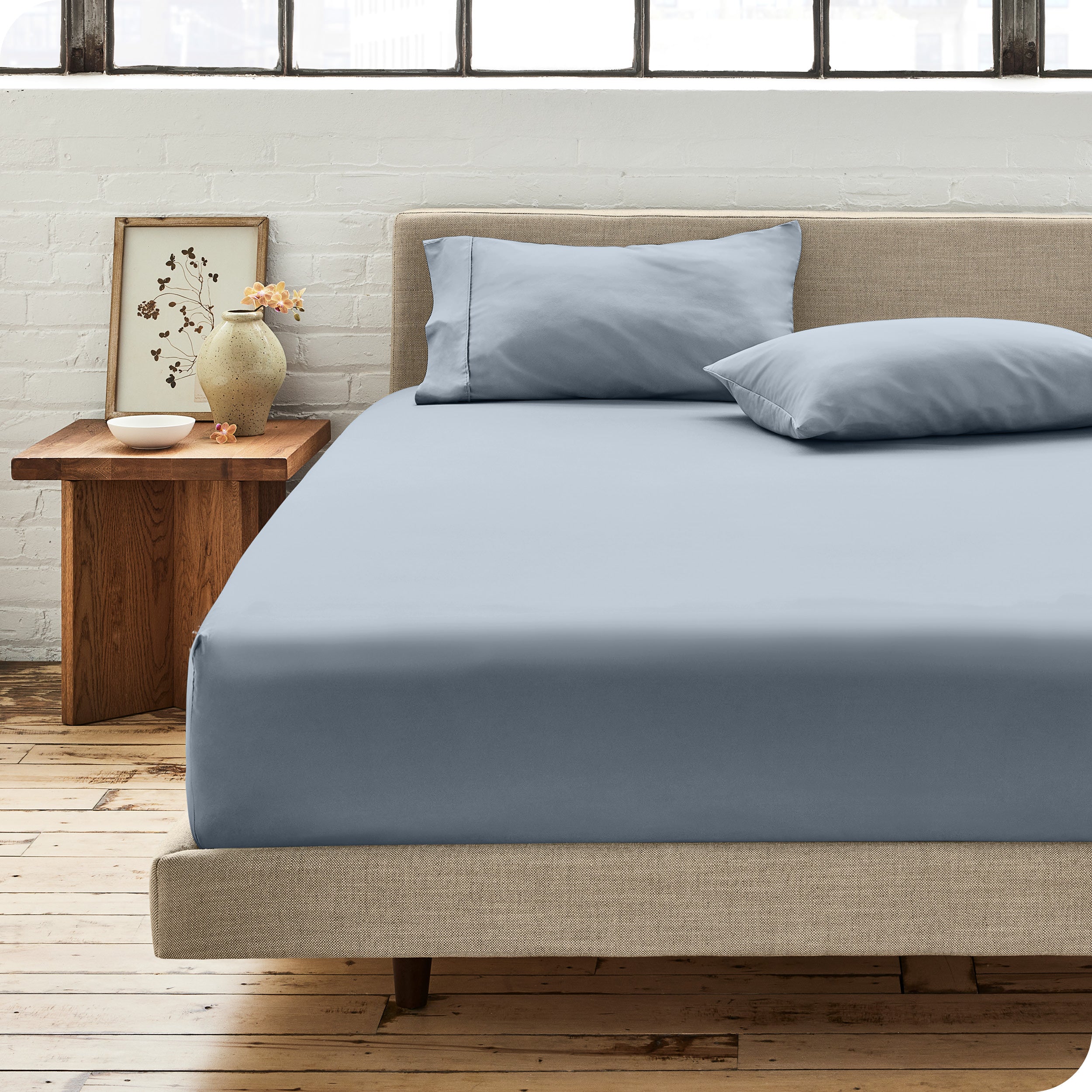 Percale fitted sheet on a mattress with matching pillowcases on pillows
