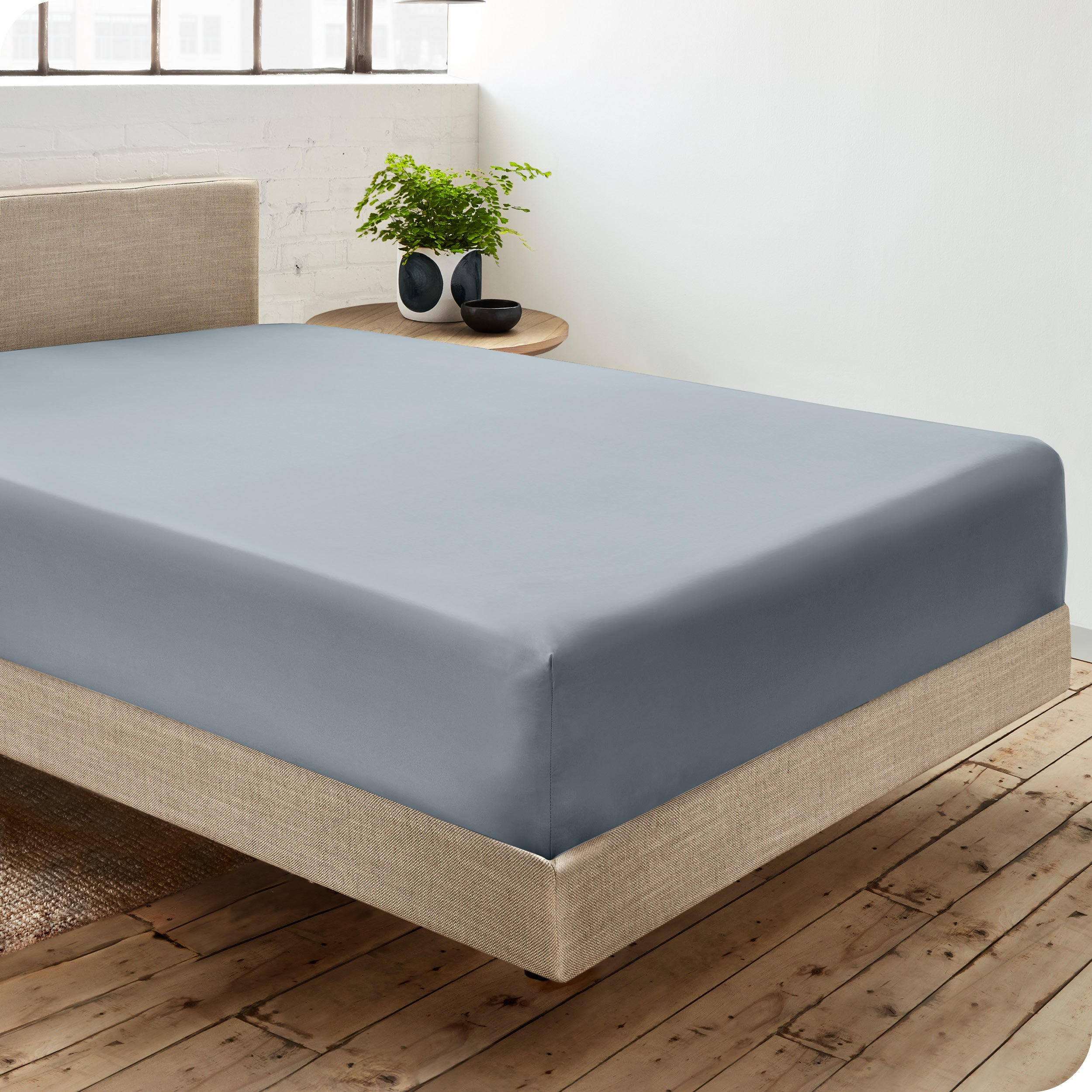 A single organic cotton fitted sheet on a bed