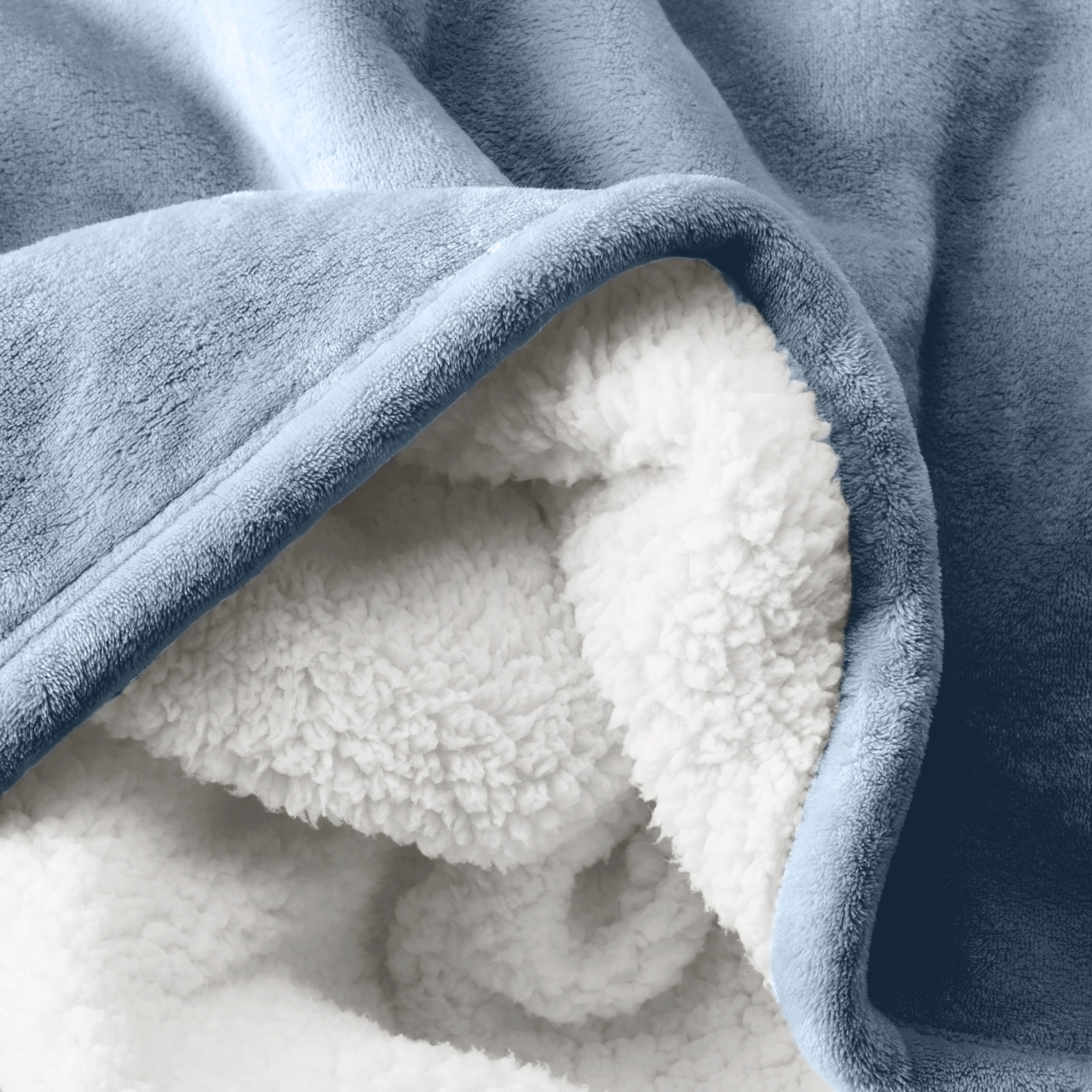 Close up of sherpa blanket showing texture of velvety soft side and sherpa backing