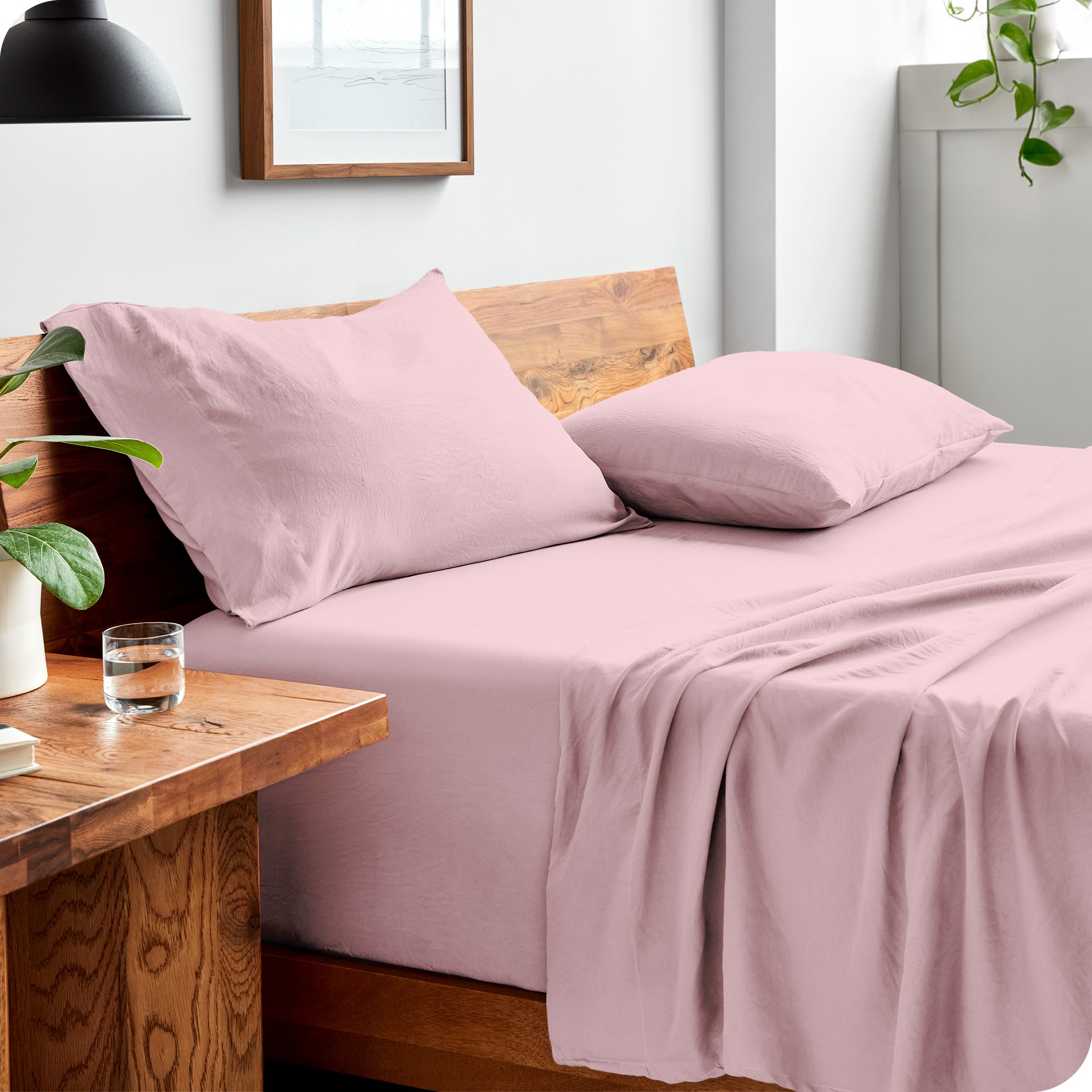 Side view of bed made with fitted sheet, pillowcases, and top sheet