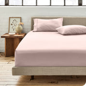 Percale fitted sheet on a mattress with matching pillowcases on pillows