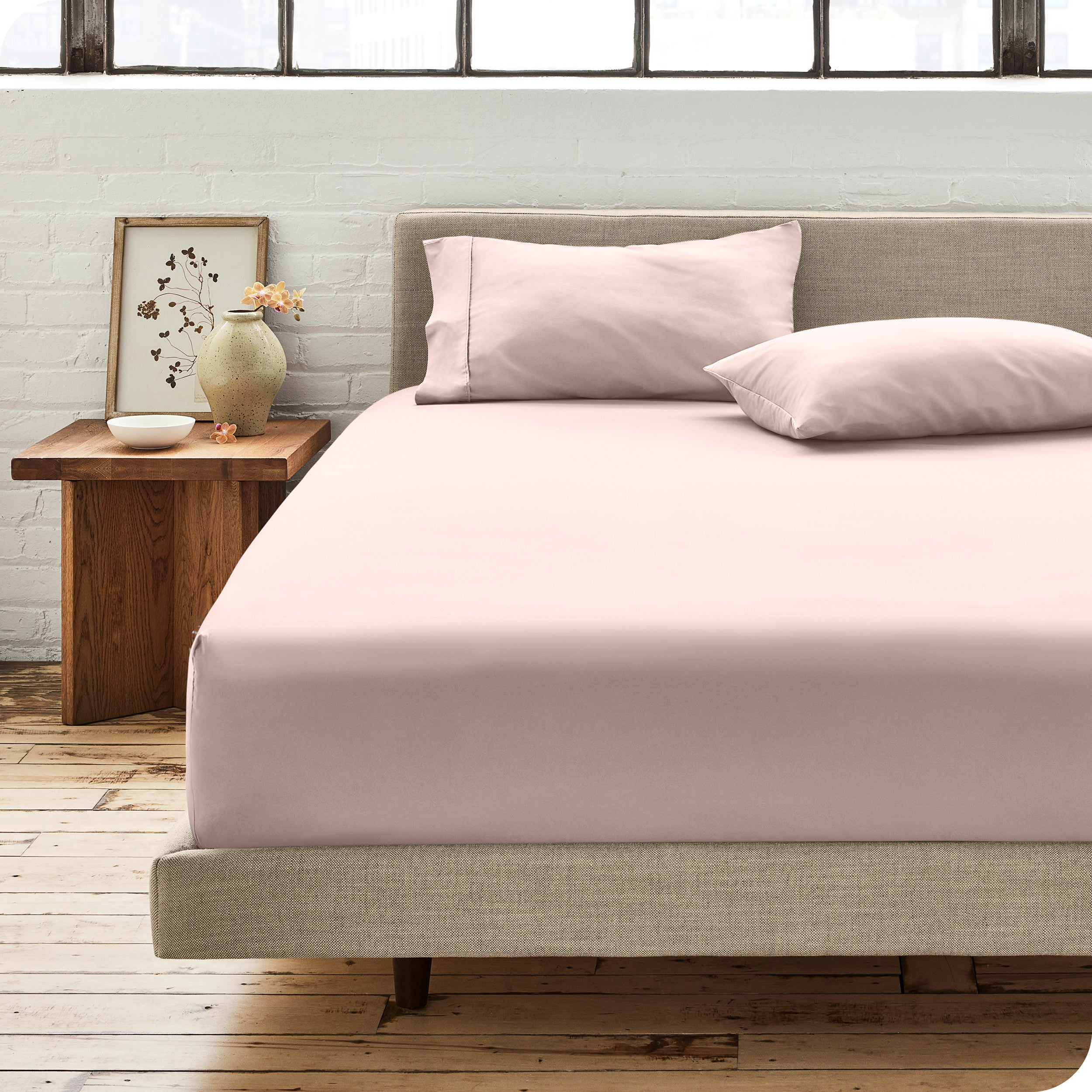 Percale fitted sheet on a mattress with matching pillowcases on pillows