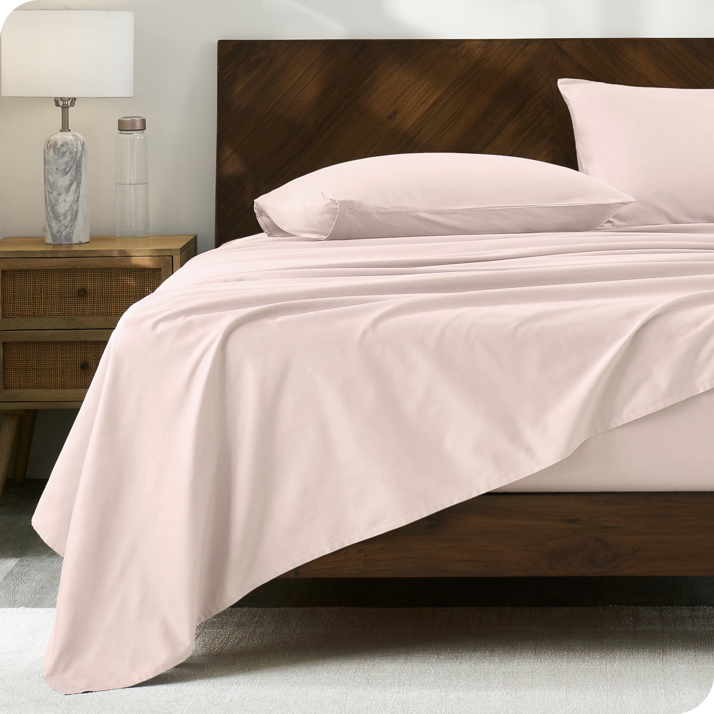 Percale sheet set on a bed with a wooden headboard