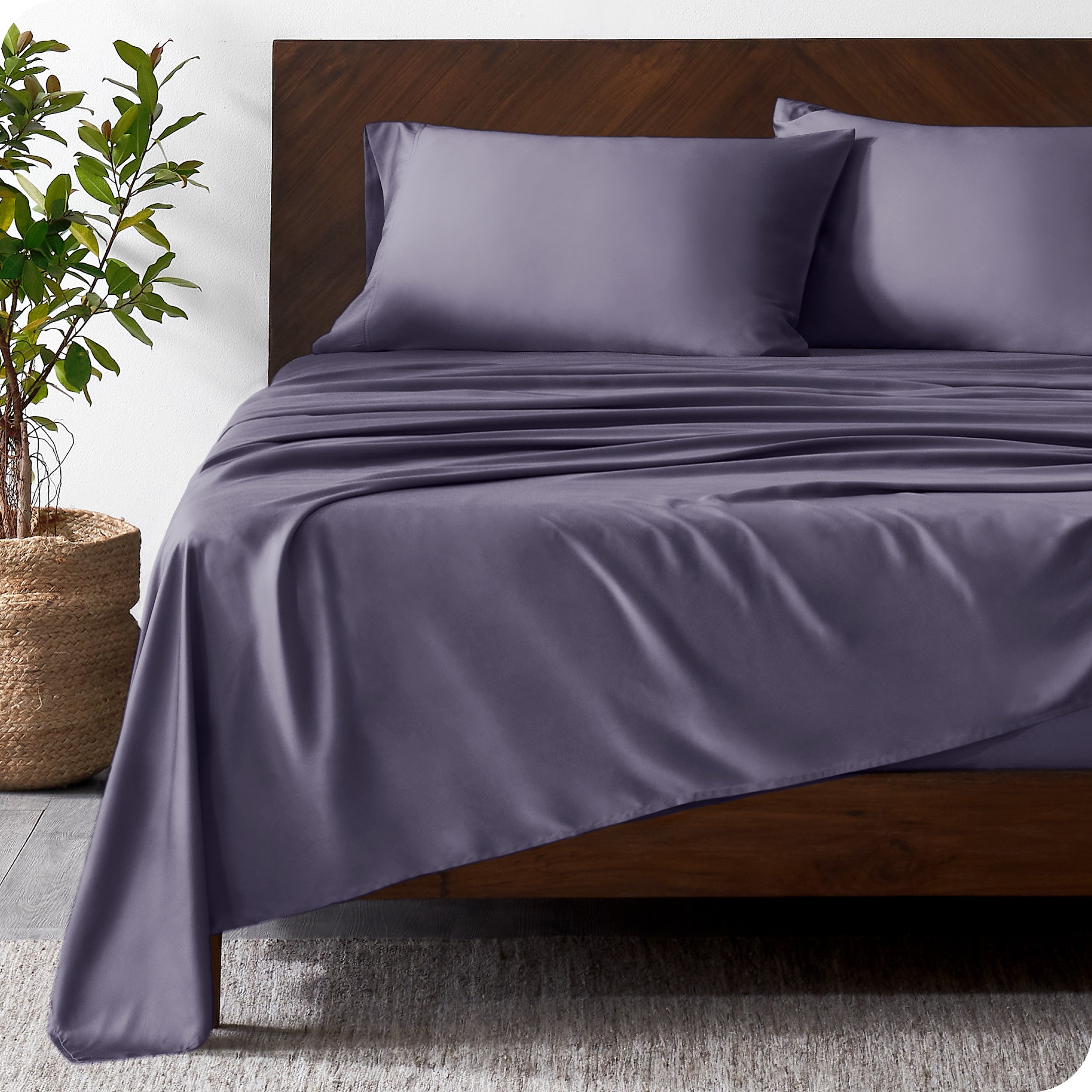 Wooden bed frame with bamboo sheets on the bed