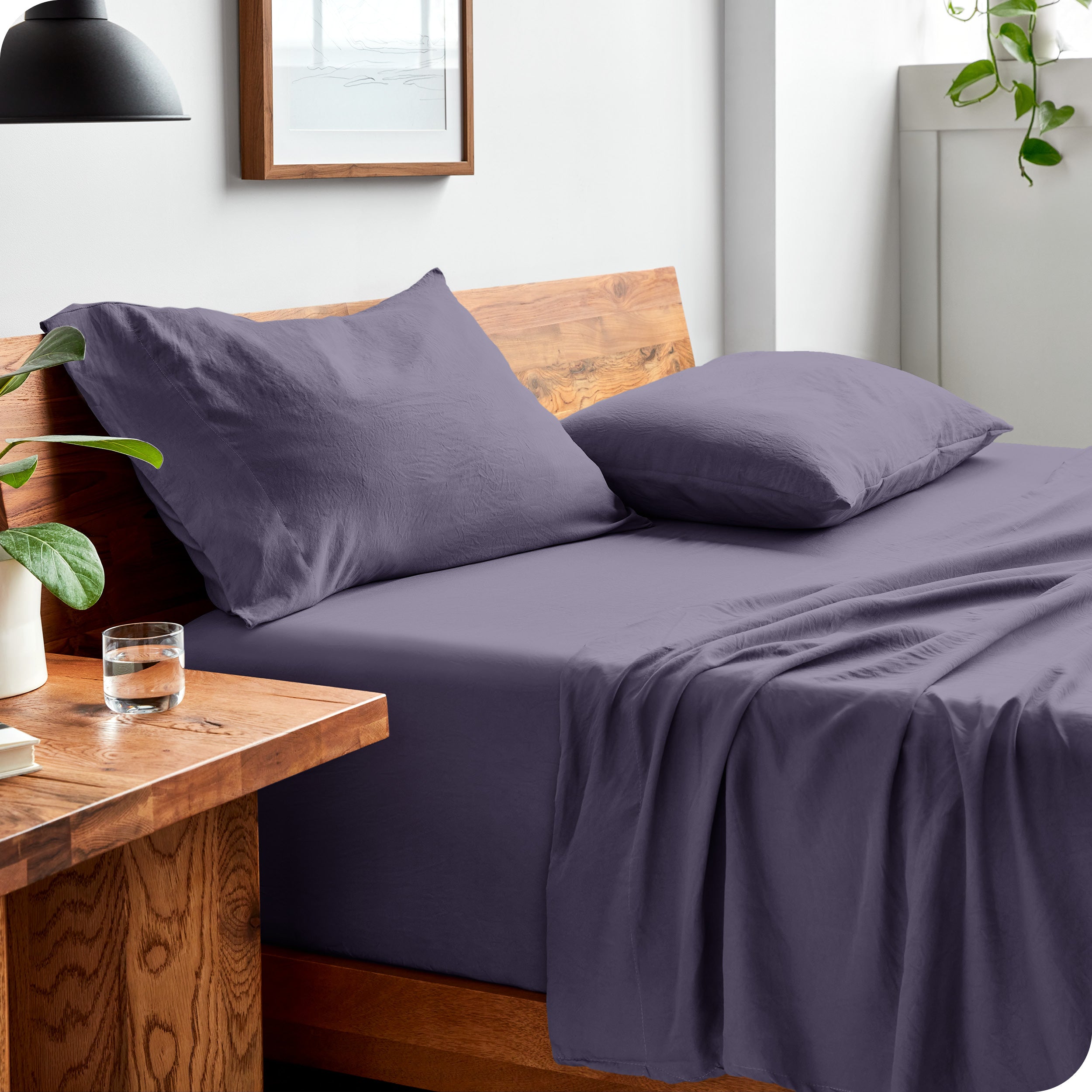Side view of bed made with fitted sheet, pillowcases, and top sheet