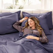 A woman sleeping on a bed made with organic cotton sateen sheets and pillowcases