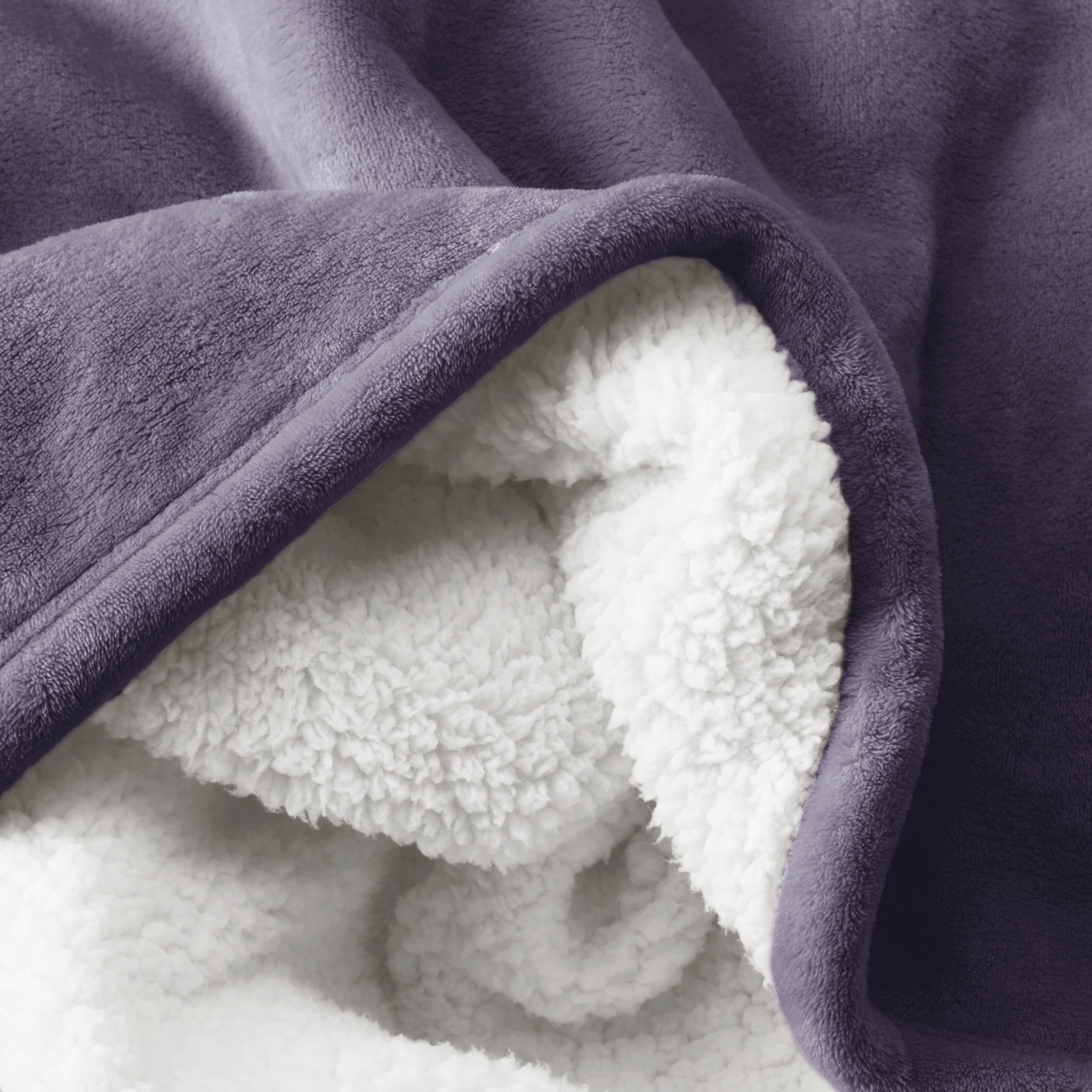 Close up of sherpa blanket showing texture of velvety soft side and sherpa backing