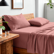 Side view of bed made with fitted sheet, pillowcases, and top sheet