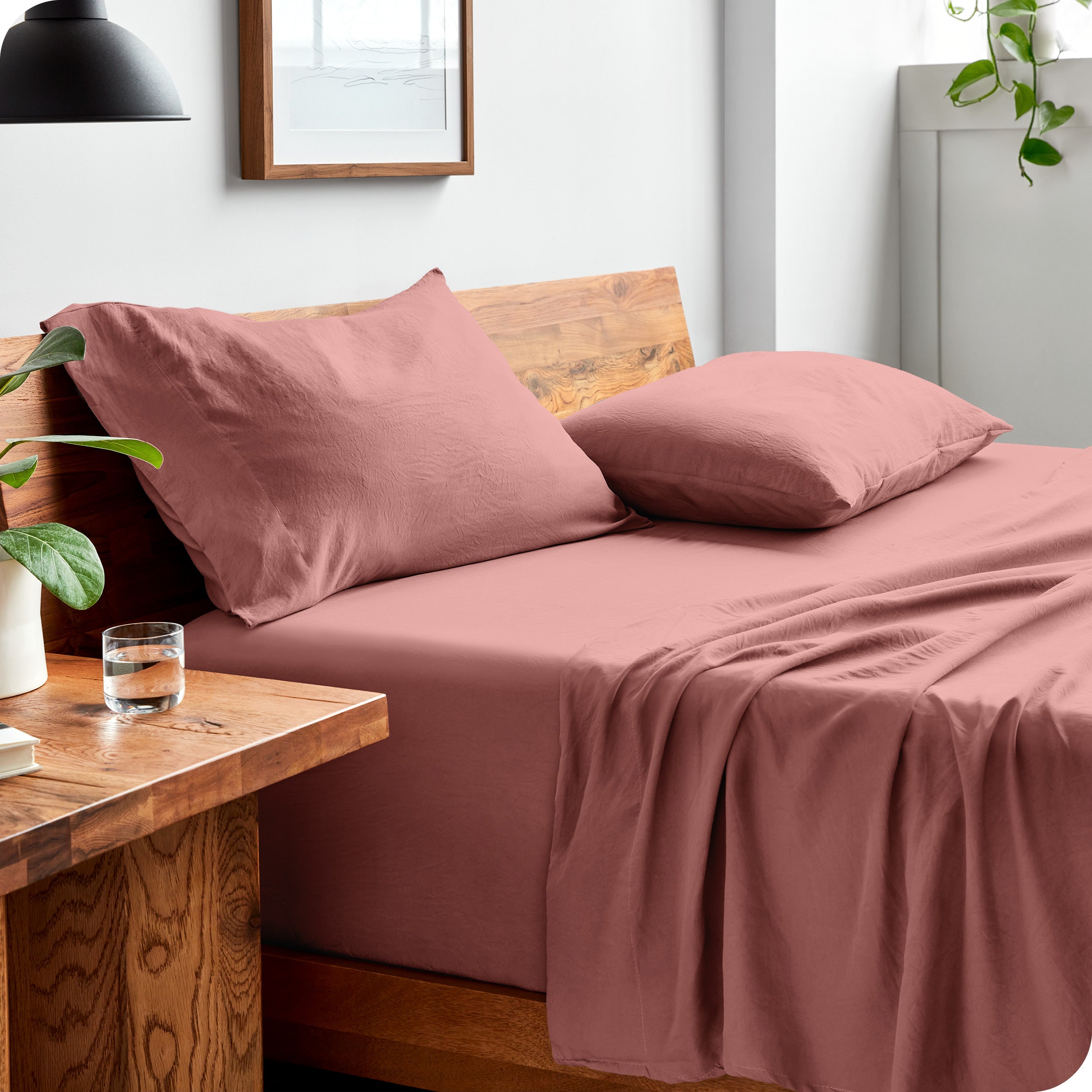 Side view of bed made with fitted sheet, pillowcases, and top sheet