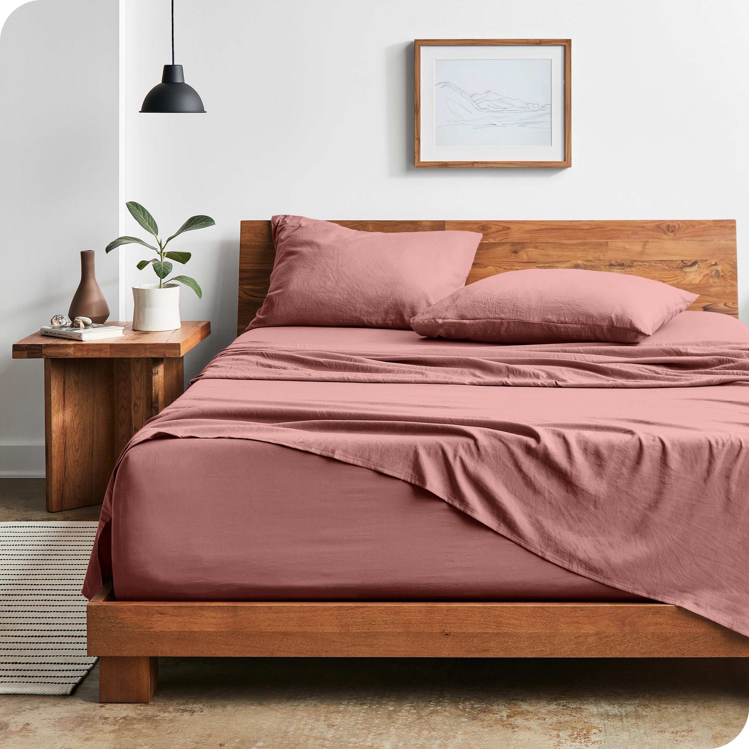 Modern bedroom with Sandwashed sheets draped over the end and side of mattress
