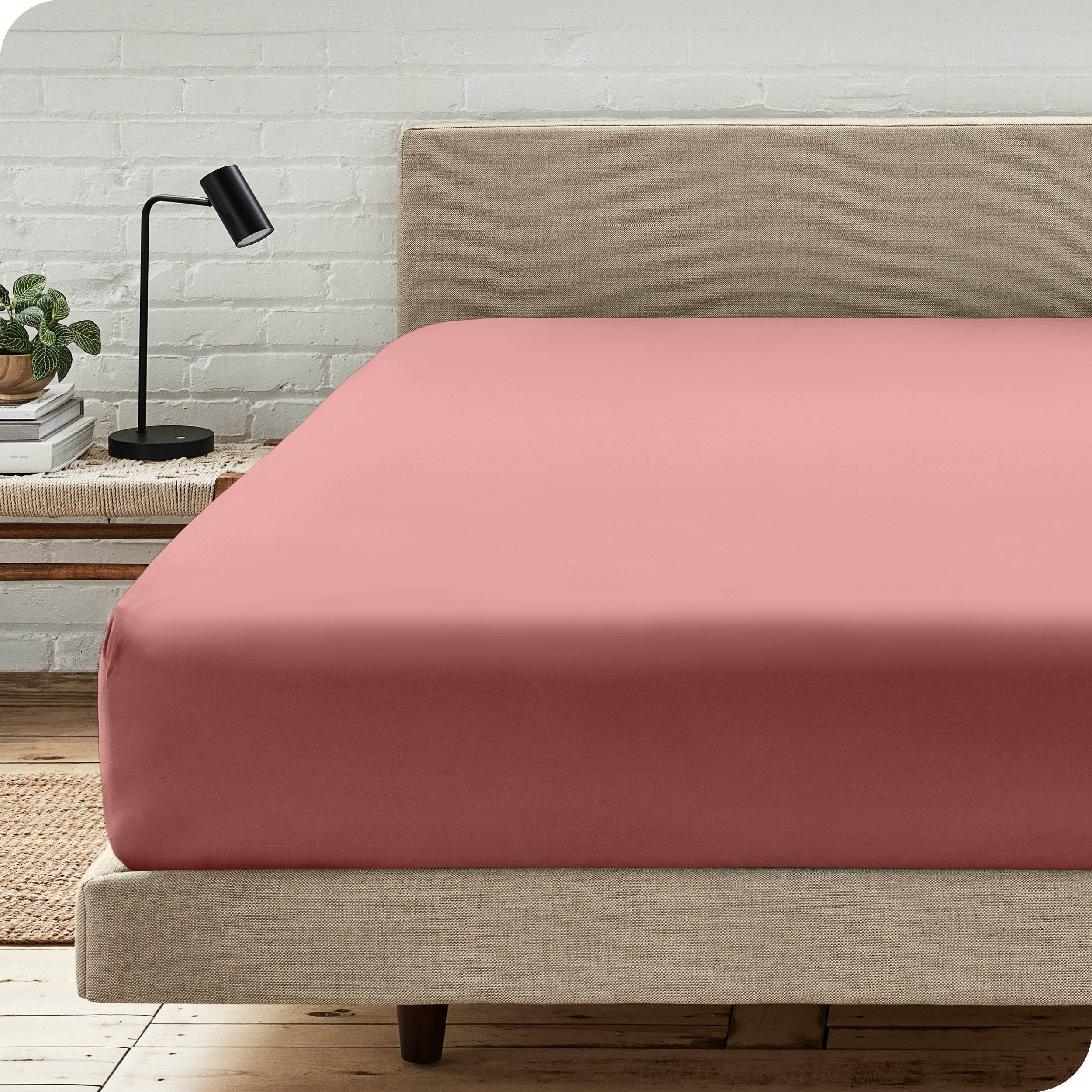 A bed with a microfiber fitted sheet on the mattress. 