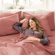 A woman sleeping on a bed made with organic cotton sateen sheets and pillowcases