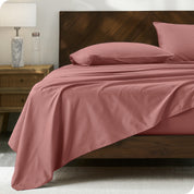Percale sheet set on a bed with a wooden headboard