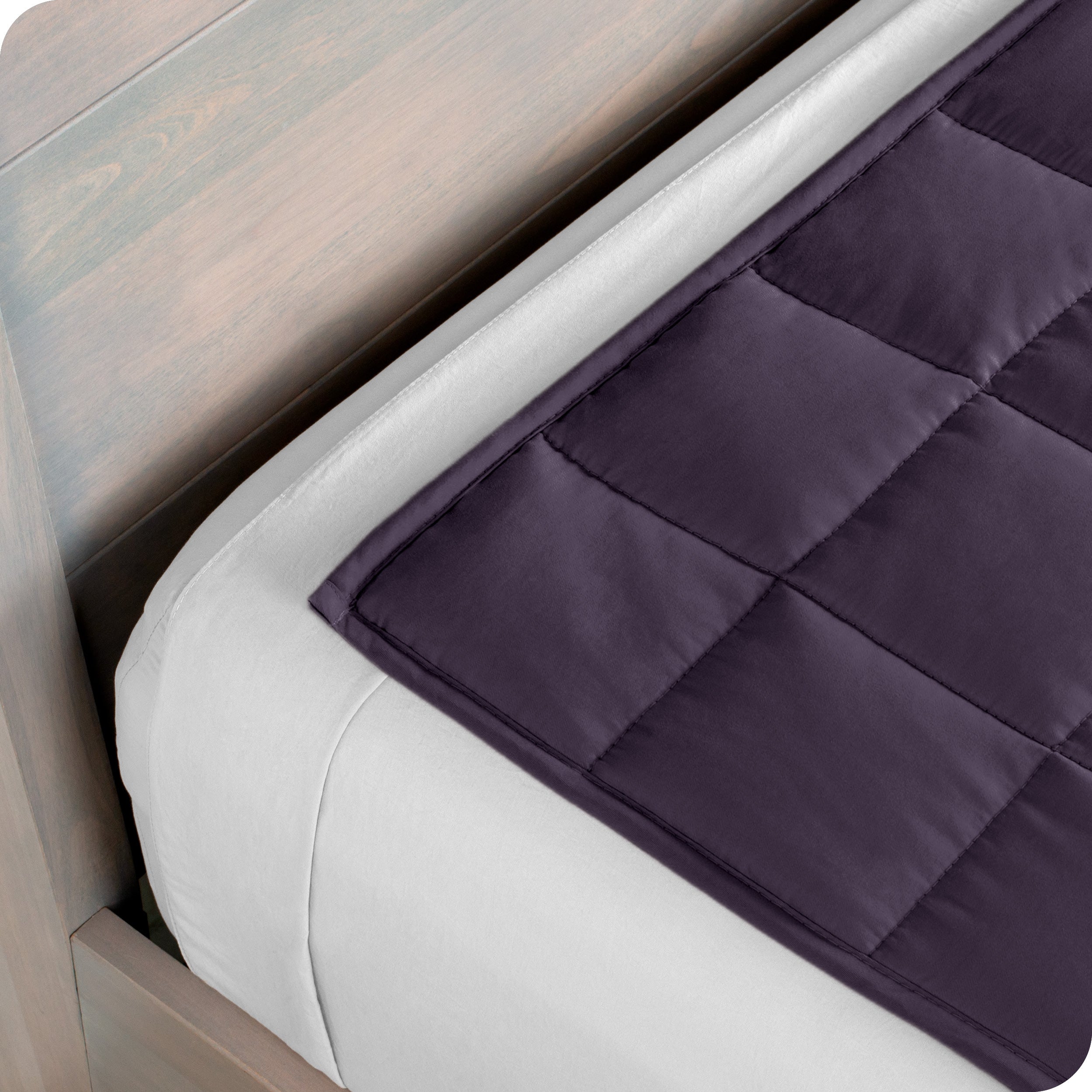 Close up of the corner of a weighted blanket on a bed