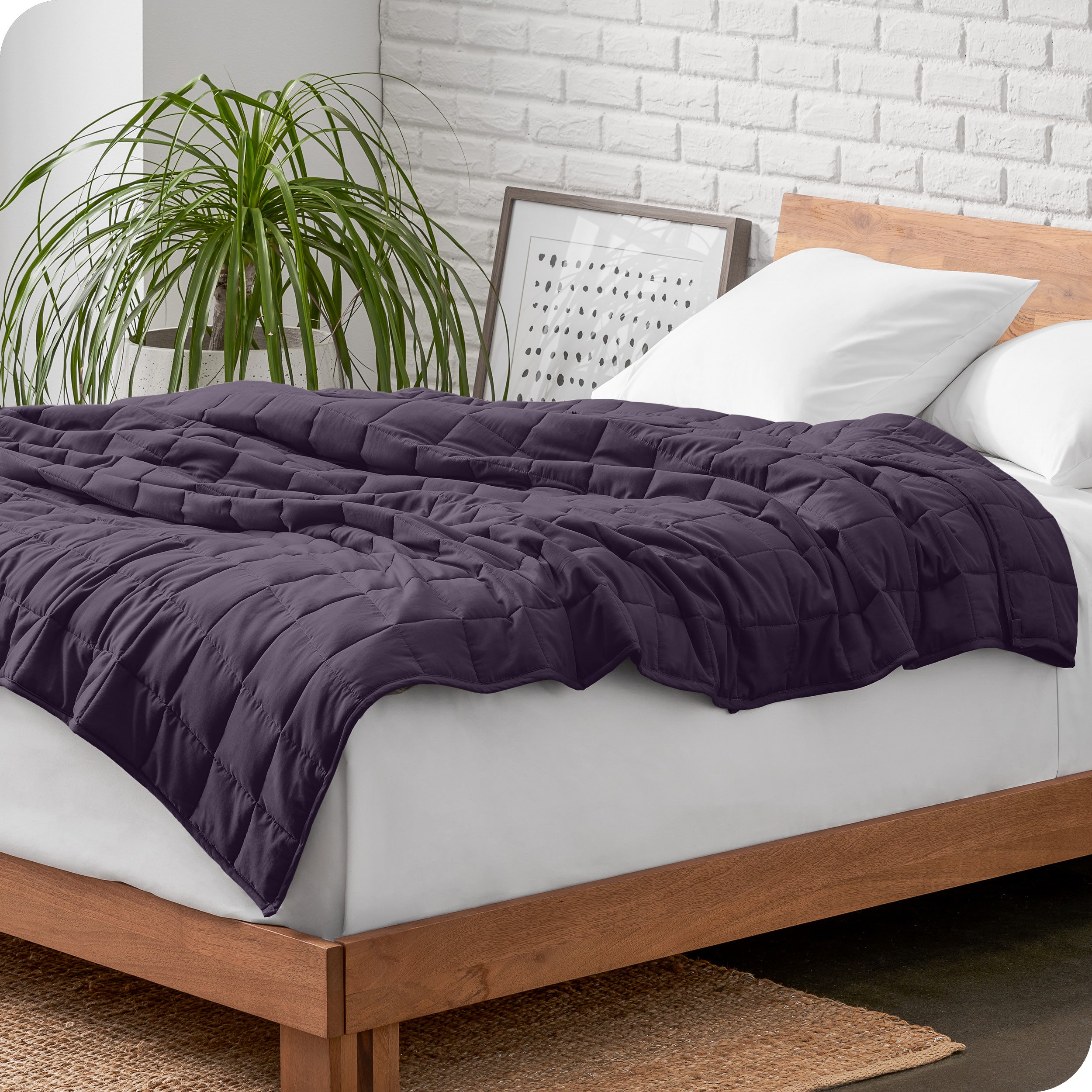 A cotton weighted blanket is loosely draped over a bed