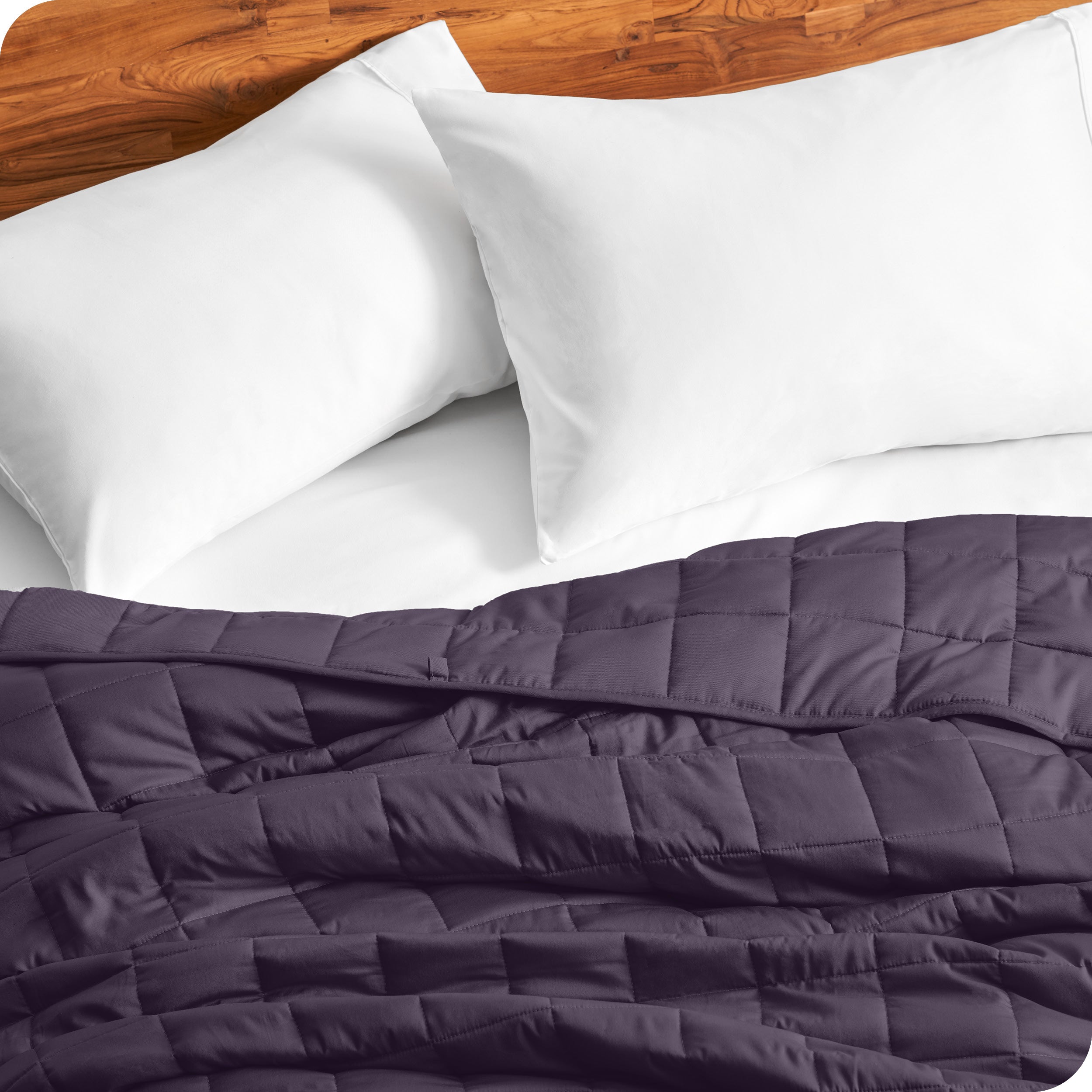Close up of a weighted blanket on a bed with  2 pillows