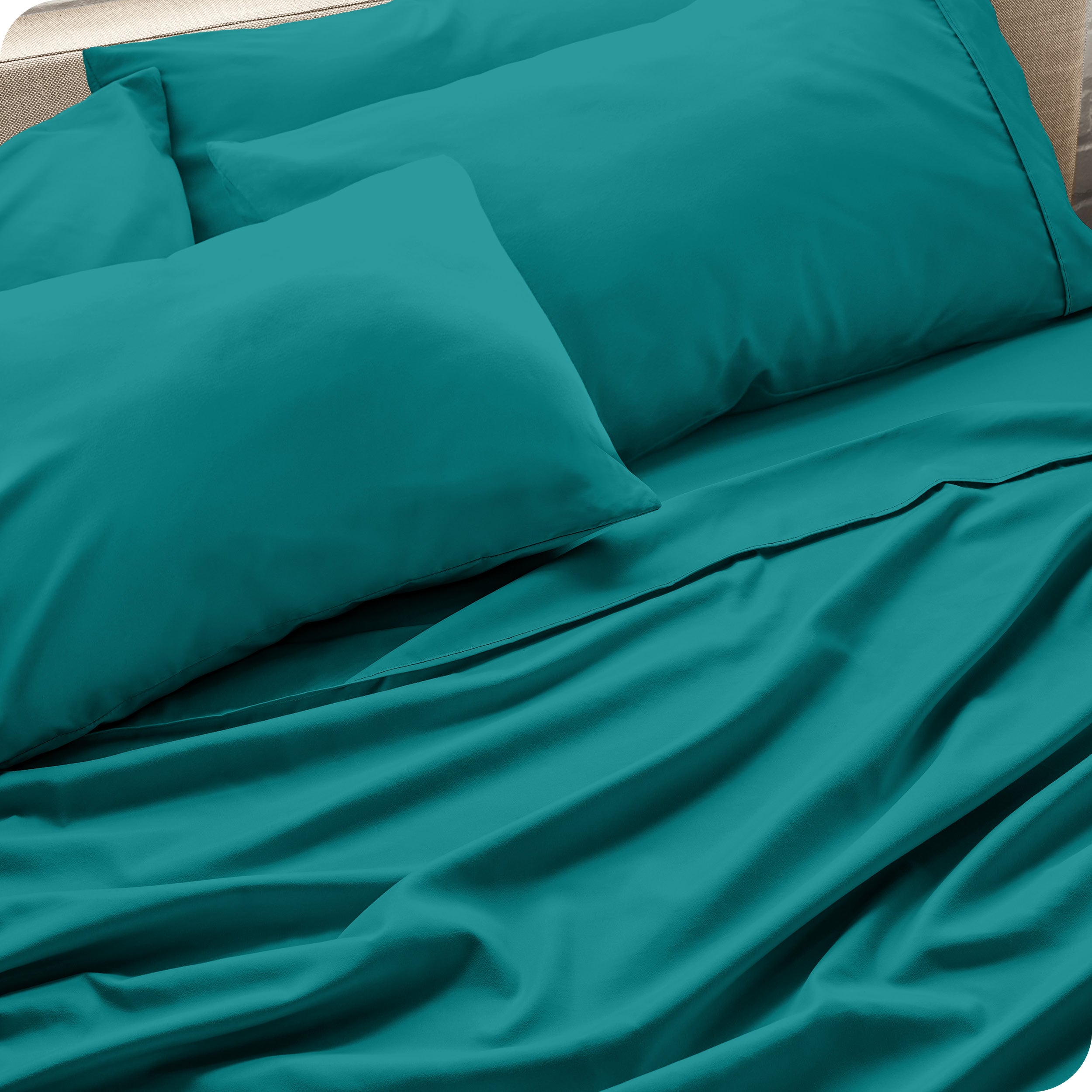 Close up of the microfiber bed sheets on a bed with four pillows.