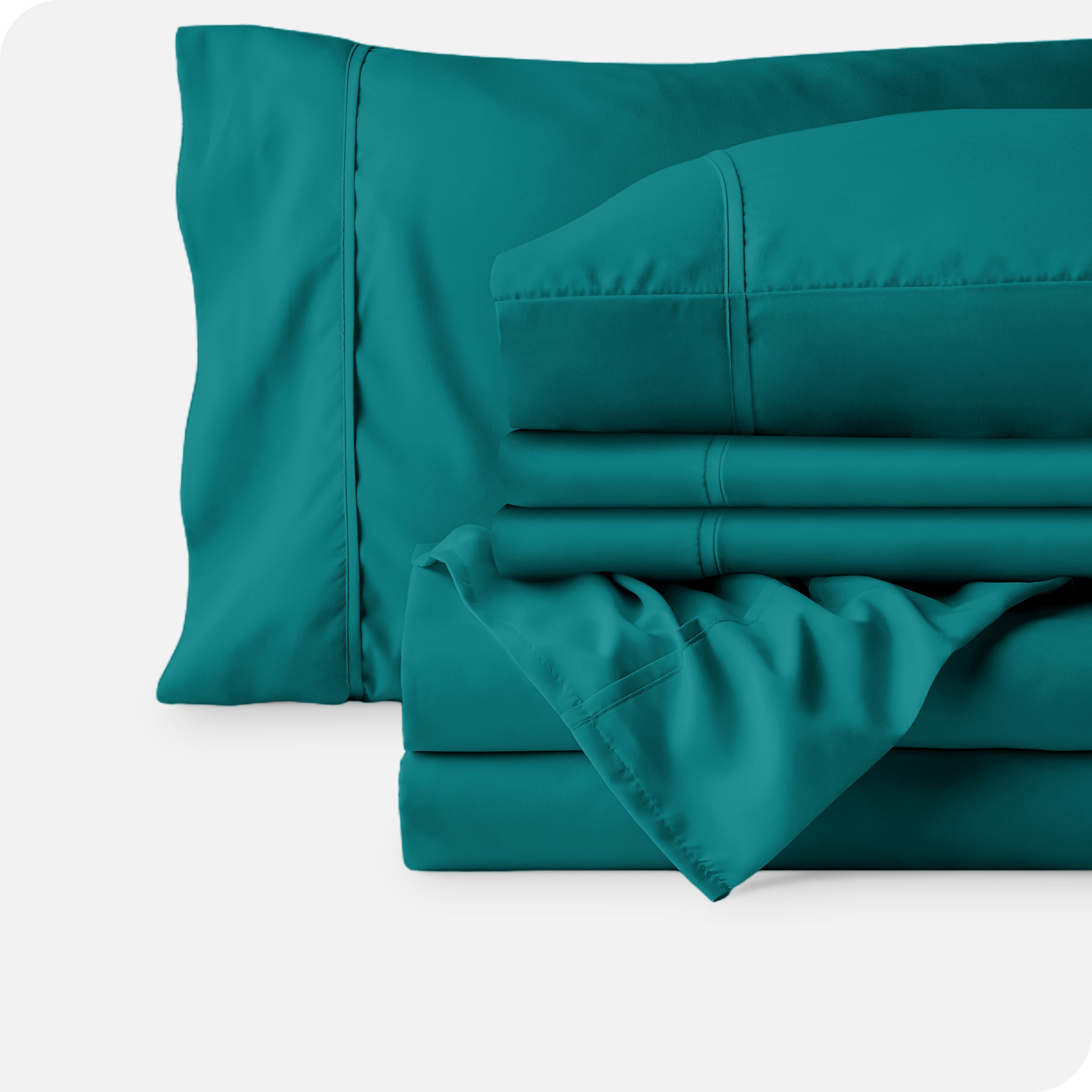 Microfiber sheets neatly folded with corner draped over, two folded pillowcases and two display pillows.