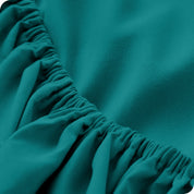 A modern bed with a fitted microfiber sheet on it