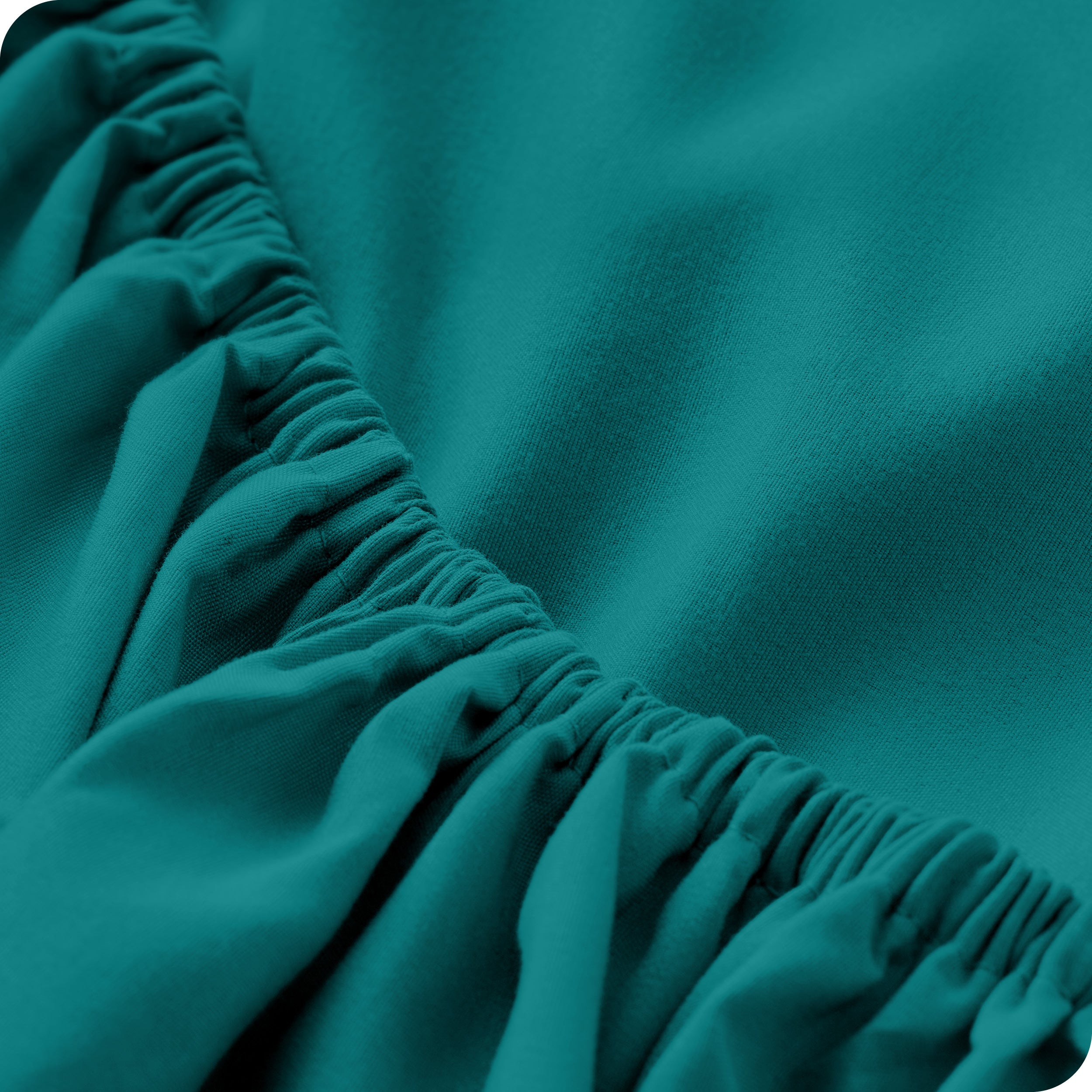A modern bed with a fitted microfiber sheet on it