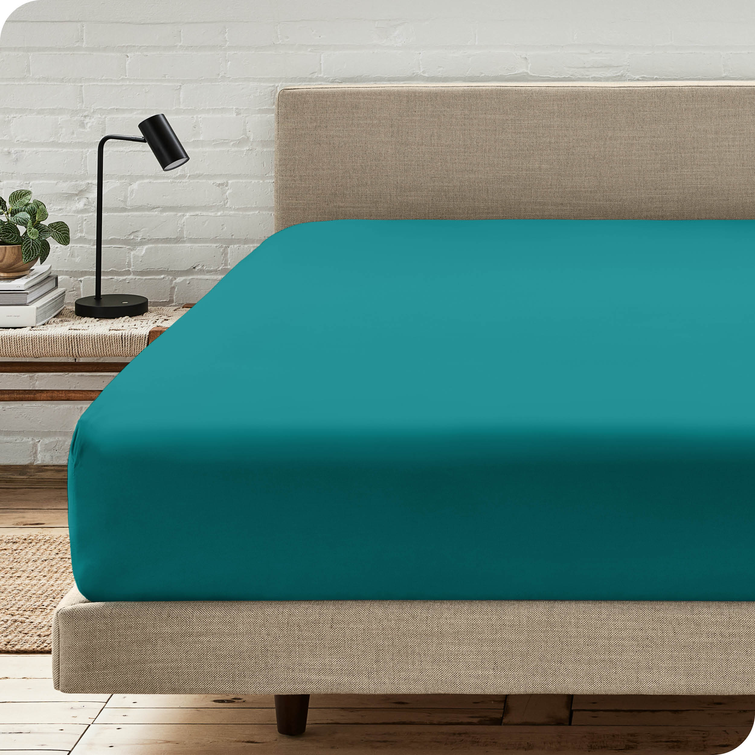 A bed with a microfiber fitted sheet on the mattress. 