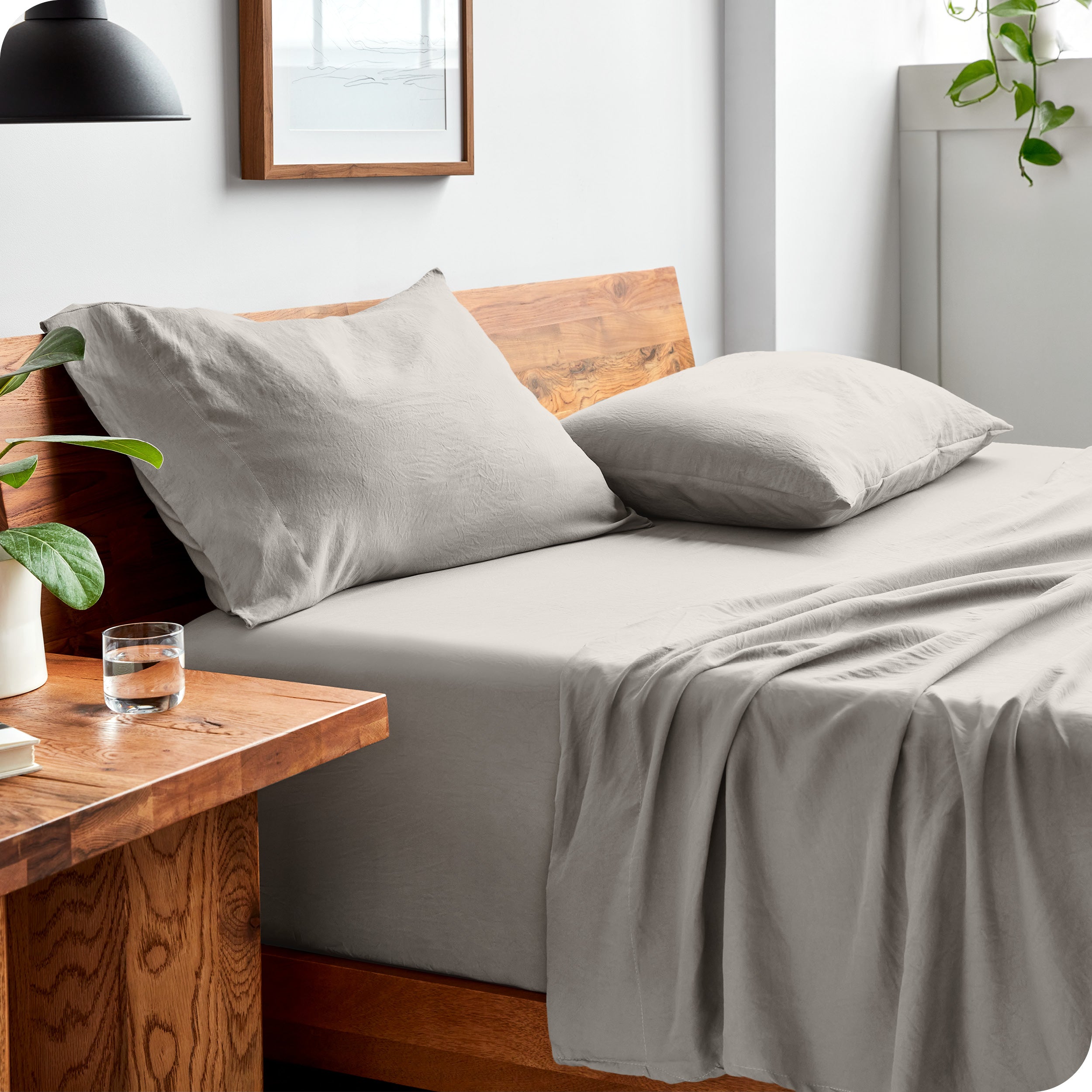 Side view of bed made with fitted sheet, pillowcases, and top sheet