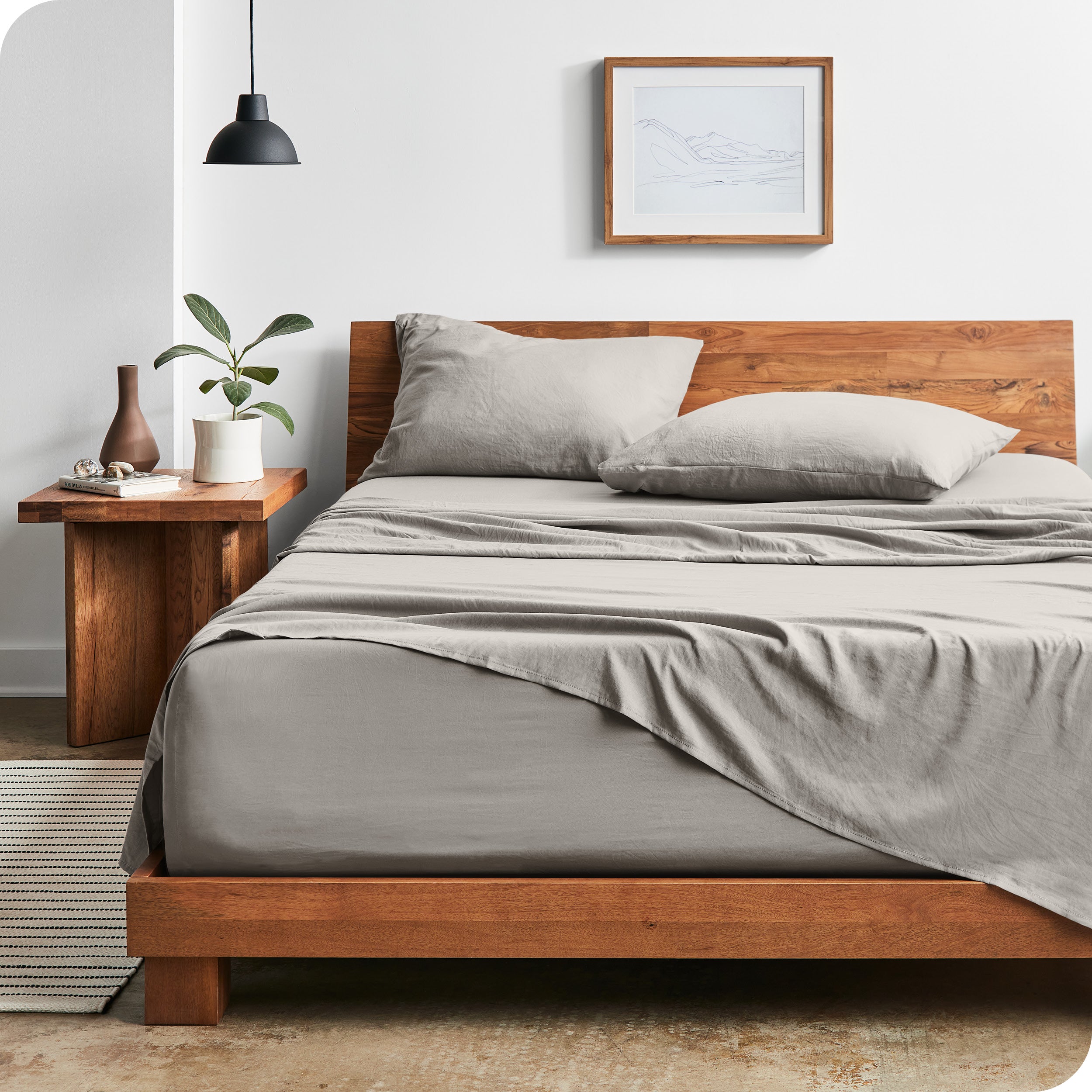 Modern bedroom with Sandwashed sheets draped over the end and side of mattress
