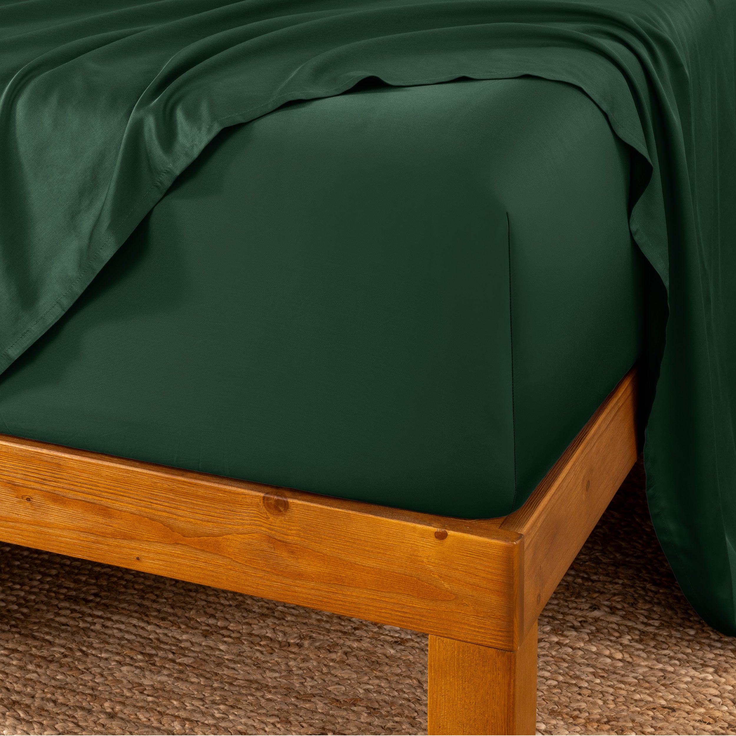 Bed sheets on a wooden bed frame with a brown carpet background