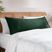 Bamboo pillowcase on a bed with white bedding and a wooden headboard.